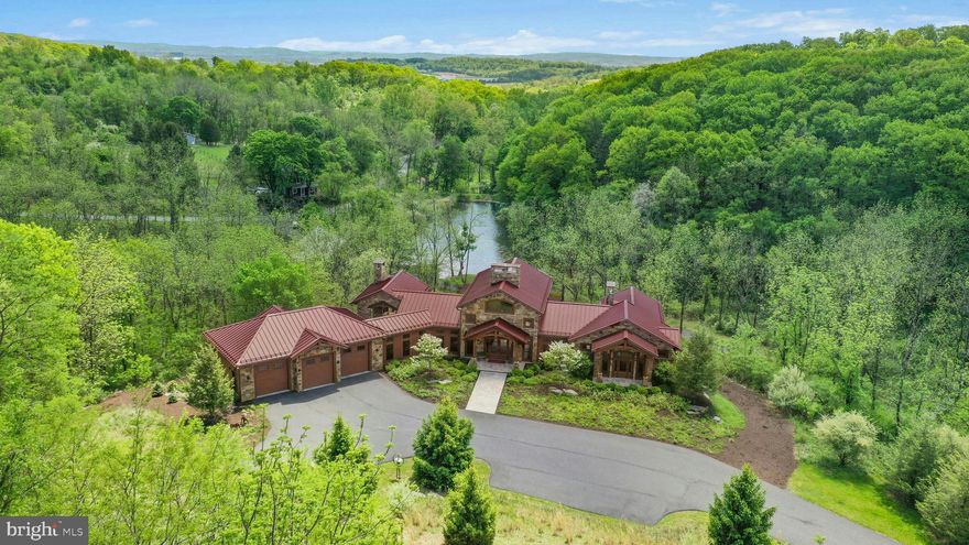 Captivating panoramas unfold through walls of glass, perfectly positioned in a stunning array of interior and exterior spaces. Surrounded by 53 acres of woods, wildflower fields, multiple streams, lake, and pond, the distinctive design creates one of the most noteworthy properties to ever have come on the market. Spectacular architectural elements and a unique composition of finishes and features are executed with exceptional craftsmanship and a timeless design, blending sophisticated details with contemporary vaulted spaces in a whimsical and inviting ambience. A fabulous interior with reclaimed wood produces vaulted spaces that will take your breath away. This exceptional house presents marvelous architectural features at every turn, dramatically combining space, light, and imagination.
 
The custom design captures the elegant interior one has come to expect in estate quality properties, where exquisite workmanship and detailed execution define each room. The extraordinary great room, enhanced by walls of south-facing windows, has arched king post timber trusses, reclaimed oak ceiling, floor-to-ceiling, two-sided stone fireplace and magnificent custom lighting designed to fit the scale of the soaring spaces.
 
Here, indoor to outdoor living has been reimagined, with rooms of grand proportions that flow into each other, boasting all the accoutrements that make for ease of living. The state-of-the-art kitchen has only the finest of appliances and custom cabinetry and opens to the sights and sounds of a unique natural setting, with an outdoor kitchen, multiple terraces, courtyard with spa, and fireside seating perfect for hosting significant gatherings with ease.
 
The primary retreat, with an exquisite bath and dual wardrobe rooms, opens to a secluded terrace overlooking a custom arched footbridge connecting the home to the converted stone barn and large pond. Enticing one to embrace the acreage, there are miles of walking trails, allowing for long hikes without ever leaving the property.   
 
Curated to provide an estate that offers the ultimate in relaxation and rejuvenation, there are multiple venues to explore. Among this is the converted stone barn, offering varied opportunities for extended use. Heated and cooled, with an upper floor of vaulted space, the barn has currently been used as a studio and office, offering a significant nod to its original character. This space is an artistic tableau, inviting all to re-invent a purpose beyond the original. Relax…invent…write…and create, overlooking the lake’s inspiration and the beauty of all that is Peaceful Valley. These estates are rare now, but this gracious home is an example of one of today’s best properties, offering full-time or part-time living at one’s whim.