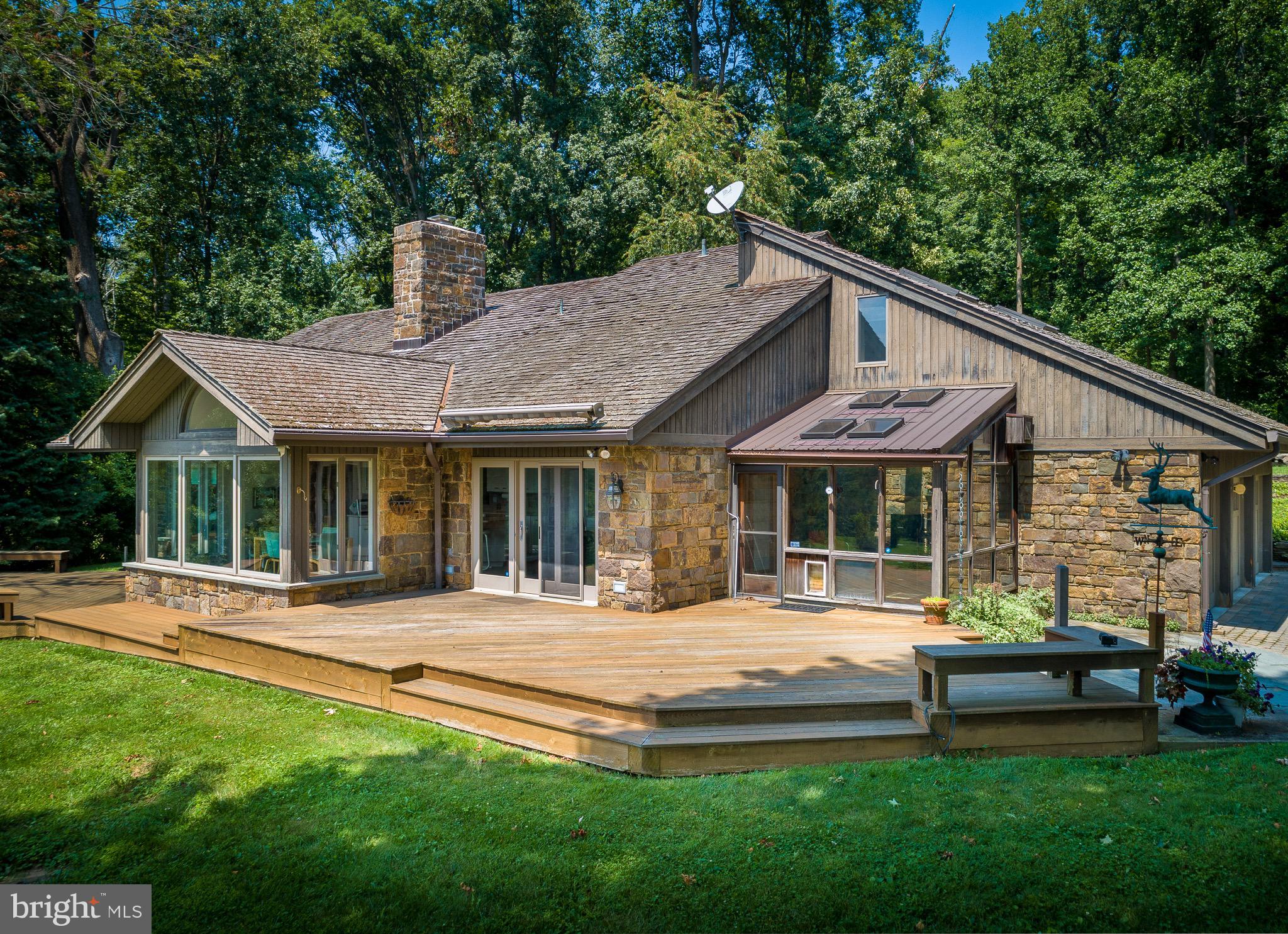 Set on 19 private acres and situated high on a hill, this property delivers one of the best views in Chester County. It is also surrounded by hundreds of acres of preserved land, making this a rare opportunity for a buyer who values peace and quiet. The not-far-off-the-beaten-path location is an excellent balance of bucolic setting and convenience, with schools, parks, shopping centers, and major highways all easily accessible. The vibrant downtown of Phoenixville is just 12 minutes away. This well-maintained property offers a comfortable and inviting living space, perfect for families or individuals looking for a peaceful retreat.
Upon entering the home, you are greeted by a spacious and bright living room, featuring large windows that allow natural light to flood the space and help to showcase the impressive hillside views. The open floor plan seamlessly connects the living room to the adjacent dining area, creating an ideal space for entertaining guests or enjoying family meals.
The kitchen is a chef's dream, boasting modern appliances, ample cabinet space, and a convenient breakfast bar. With its sleek design and functional layout, this kitchen is sure to inspire culinary creativity.
The home offers three generously sized bedrooms, each providing a peaceful sanctuary for rest and relaxation. The main floor primary bedroom features an en-suite bathroom, providing privacy and convenience. The additional bedrooms share a well-appointed full bathroom.
The outdoor space is equally impressive, with a spacious backyard that offers endless possibilities for outdoor activities and gatherings. Whether you prefer to relax on the patio, tend to a garden, or create a play area for children, this backyard provides the perfect canvas for your imagination. A tennis court adds more recreational fun.
Additional features of this property include a three car garage, providing ample storage space, and a laundry room for added convenience. A custom detached studio / guest house with a powder room provides additional flexible space for an office, artist, hobbies, exercise, etc. Do not miss out on a chance to make this beautiful property your new home!