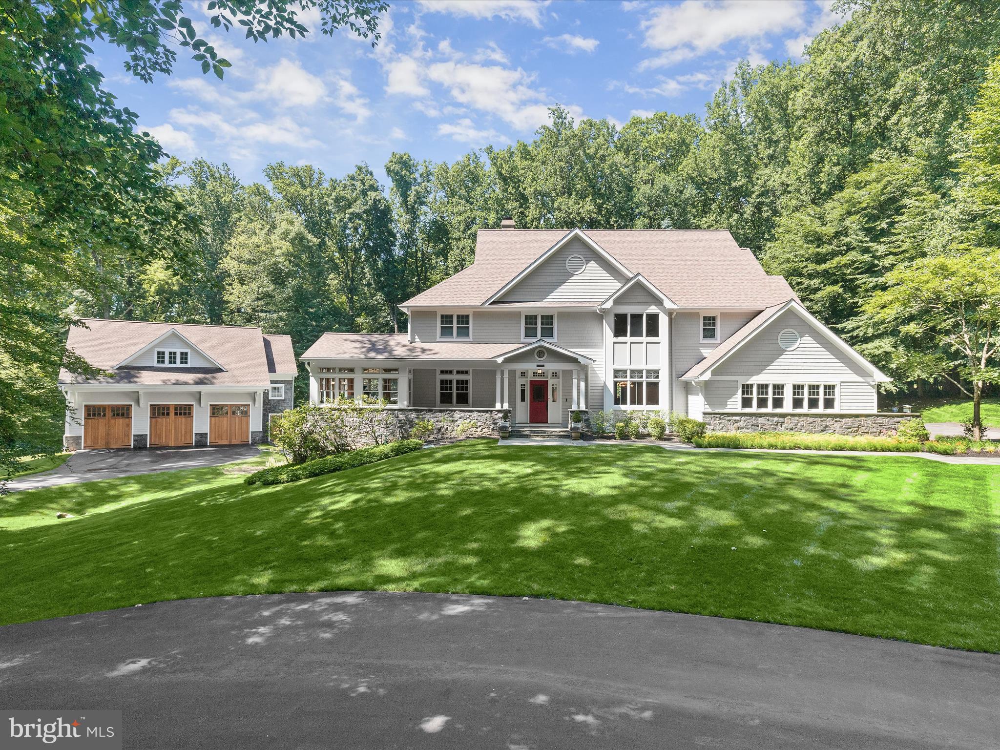 A private retreat like no other—this exquisite Craftsman-style estate is gracefully tucked away on over 3 acres in Clarksville’s prestigious Chapel Woods community. Surrounded by lush landscaping and natural beauty, the property offers a serene oasis featuring a glimmering fish pond and built-in hot tub, an expansive deck draped in blooming wisteria, and multiple outdoor living spaces, perfect for both grand entertaining and peaceful relaxation. With over 7,000 sq ft of impeccably finished living space, the home exudes warmth and timeless craftsmanship. Rich cherry wood millwork, maple floors, mahogany doors, soaring vaulted ceilings, and artful stained glass accents create a sense of refined luxury throughout. The two-story family room centers around a wood-burning fireplace with a rustic wood mantle and custom stonework, while the formal living and dining rooms are adorned with elegant wood detailing. The gourmet kitchen is a chef’s dream, offering a massive center island, granite countertops, Sub-Zero refrigerators, and custom solid wood cabinetry—flowing seamlessly into a light-filled breakfast room with stained glass touches and views of the enchanting backyard. A main-level home office, powder room, and spacious laundry room provide convenience and functionality. Upstairs, the expansive primary suite is a sanctuary of its own, complete with a cozy sitting area enhanced by a stove, a 23’ x 12’ walk-in closet, and a lavish en suite bath with dual vanities, a soaking tub, and a spa-like frameless shower. Three additional bedrooms and two full baths complete the upper level. The fully finished lower level offers two more bedrooms, a full bath, a rec room with wet bar, a game room, hobby area, generous storage, and a wine lover’s dream wine cellar. Step outside to your own private paradise—featuring an outdoor kitchen, hot tub, stone fireplace, and paver patio that overlooks the tranquil pond and lush surroundings. A detached 3-car garage with a designer-finished floor and attached 2 car garage provide additional storage space. Recent upgrades include a new roof (2022), WHOLE-HOUSE generator, HVAC (2019), water heater (2025), refinished cedar shake siding, Sub-Zero refrigerator, upper-level hardwoods, LVP on the lower level, all gutters have leaf guards, and whole-house sediment filters. Unmatched in privacy and elegance, this estate is ideally located near major commuter routes, premier shopping, dining, and entertainment. A truly rare opportunity to own a one-of-a-kind luxury residence.