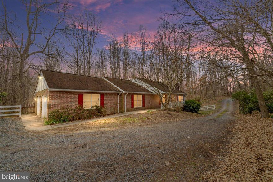 Situated on three serene acres, this private and spacious all-brick 4-bedroom, 3-bath retreat offers an exciting opportunity to build equity with thoughtful cosmetic updates - an ideal canvas for your creativity and vision. Expansive outdoor spaces include rocking chair front porch and a two-level deck that’s ideal for al fresco grilling, dining and entertaining. Interior design details include hardwood flooring in the entry, living and dining rooms, along with a cozy wood-burning fireplace. Main level features two bedrooms, including a primary suite with its own en suite bath.  Downstairs, a large recreation room provides versatile space as well as an additional bedroom. Beyond this, you’ll find a separate suite that’s ideal for multi-generational households, extended guest quarters, rental potential, or a private home office and which includes a small secondary kitchen, living area, bedroom, and full bath — a perfect setup for added flexibility. Attached dual-bay garage and ample driveway parking add convenience, while the expansive lot invites gardening, wildlife watching and outdoor living while enjoying the peaceful surroundings. Despite its tranquil setting, this home is conveniently located for commuters — just off Route 4, 12 miles to Edgewater, 15 miles to Joint Base Andrews, 20 miles to Annapolis, and 25 miles to Washington, DC.  Embrace the potential and make it your own - Come See!
