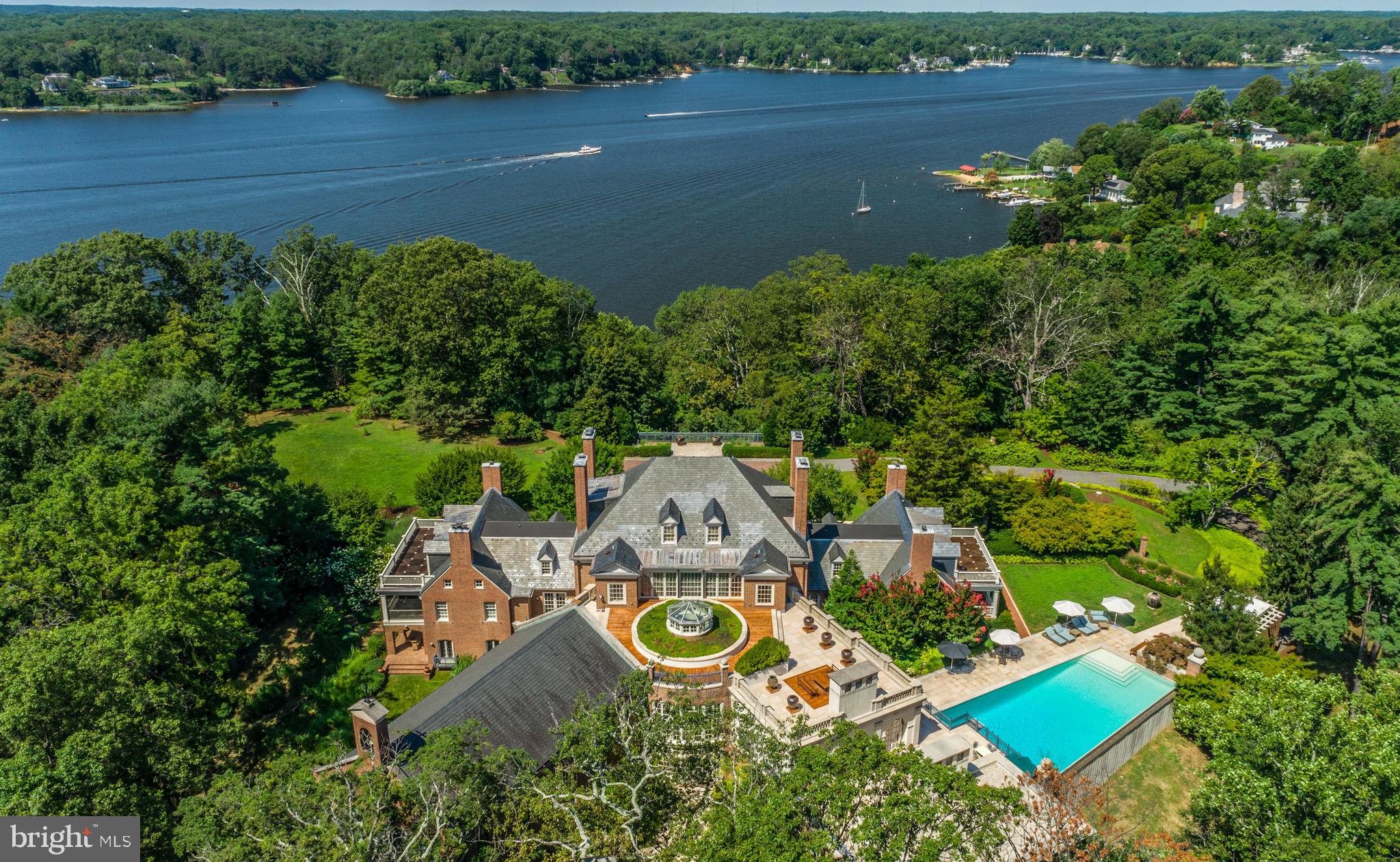 THE FRIARY a Trophy property in a league of its own! Set on 23 private acres overlooking a gracious bend of the Severn River with 1,500ft of prime waterfrontage, just minutes from downtown Annapolis and less than an hour from the nation's capital, lies one of the most distinctive estates offered for sale on the East Coast. A true architectural masterpiece, this exquisite 35,000+ sqft residence, is the result of a mammoth and complex renovation that brought it back to its classic Georgian style yet with an acknowledgment of the owner's contemporary tastes and interests. Formerly a Capuchin monastery, this stately brick structure offers modern amenities for comfortable family living yet easily accommodates elegant grand scale entertainment and private events. The attention to detail and emphasis on proportions and craftsmanship are unparalleled. The exterior features spectacular 270 degree river views, nine car garage, roof garden, pool pavilion, 60 feet infinity edge pool, tennis court and direct access by funicular to a 6 slip private dock with 10' MLW and boat lift. Step into the main core of the home, where 18th-century elements, like original heart pine floors & foyer arch moldings, have been flawlessly preserved. A cleverly designed limestone rotunda containing a conservatory & atrium lead to either of the house’s wings: the impeccably appointed guest wing with spacious common room, or the chapel-turned-ballroom with sweeping limestone fireplace, herringbone teak floors, & arched double doors with a picturesque terrace beyond. The extraordinary estate contains a total of seven bedrooms, eight bathrooms and eighteen fireplaces, formal dining room and formal parlor, commercial size gourmet kitchen, over sized ballroom, conservatory, family room, library, music room, indoor spa, game room, wine cellar, catering kitchen, work shop, and a secret vault. Additional structures on the property include a three bedroom, two bath-guest/staff house, an Asian tea house and mechanical facilities. Only minutes from Washington D.C. and multiple international airports, this elegant and opulent property is worlds away from the hustle and bustle of everyday life yet offers an easy commute to several major metropolitan cities. Unmatched opulence and privacy awaits on the Severn River!