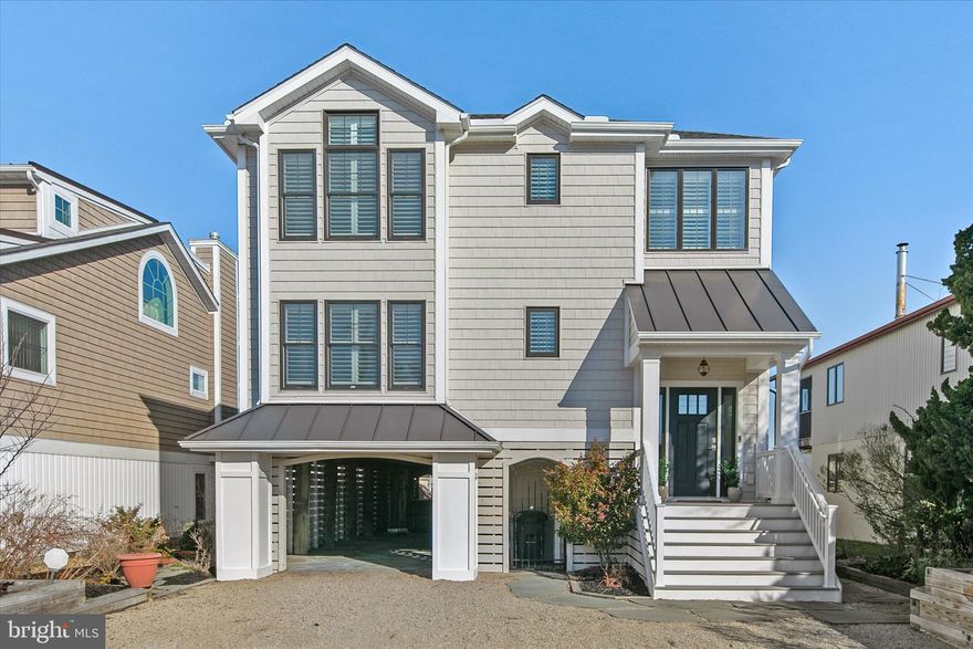 Perfectly positioned just one and a half blocks from the beach, this exceptional 4-bedroom, 3.5-bath canal-front residence in Fenwick Island offers a rare blend of refined coastal elegance, effortless waterfront living, and an unbeatable walkable lifestyle. Designed with a light-filled inverted floor plan, the home captures breathtaking sunset views over the canal and features multiple levels of outdoor living, including expansive water-facing decks and a private rooftop deck—ideal for sunset gatherings and evening entertaining.
The main living level showcases a vaulted great room anchored by a striking stone-surround gas fireplace, creating an inviting yet sophisticated atmosphere. The open-concept gourmet kitchen is equipped with Sub-Zero refrigeration, stainless steel appliances, abundant cabinetry, a butler’s pantry with a small drink/wine refrigerator, and a kitchen sink with a dedicated filtered water system. The space flows seamlessly onto spacious decks overlooking the canal, enhancing indoor-outdoor entertainment.
The lower-level welcomes guests with a tiled entryway leading to a beautifully appointed secondary living space complete with a wet bar (sink and beverage refrigeration) and sun-filled lounge—ideal for relaxed evenings by the water. Throughout the home, inlaid oak hardwood flooring, designer lighting, ceramic tile, plush carpeting, and plantation shutters throughout reflect meticulous attention to detail. Multiple well-designed closets are found throughout the home, including large center closets pre-framed for future elevator installation, along with a spacious utility storage closet in the carport area—perfect for bikes, beach chairs, and coastal gear.
Outdoors, the property unfolds as a private waterfront retreat. Thoughtfully designed hardscaping includes slate patios, Trex decking, a serene koi pond and water feature, and an expansive covered entertaining area beneath the home featuring a custom-built bar, a brand-new seven-person hot tub, and a private outdoor shower designed for complete privacy. With direct canal access from the backyard, you can step effortlessly from patio to boat, jet skis, or paddleboards.
Additional comfort and convenience features include central air conditioning, plus a separate ductless heating and cooling system in the sunroom, allowing for year-round enjoyment. The home is equipped with smart-home technology throughout, including Ring security cameras, smart thermostats, smart locks, and smart smoke alarms—all accessible remotely. An EV (Tesla) charging station is conveniently located in the carport, and propane lines are already in place to both outdoor decks for optional future fire pit installation.
Beyond the home, enjoy the convenience of walking to exceptional local restaurants, boutique shopping, mini golf, and coastal attractions, making this property ideal as a primary residence, second home, or investment opportunity.
This luxury canal-front home near the beach offers timeless design, exceptional indoor-outdoor living, modern amenities, direct water access, and a vibrant walkable location, an extraordinary opportunity to own a premier Fenwick Island coastal retreat.