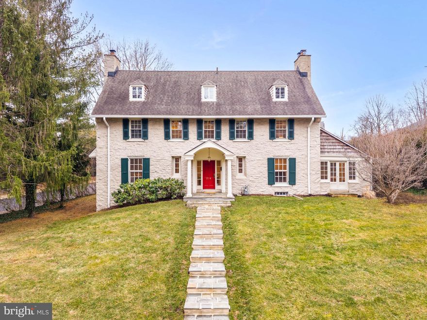 This classic Stone Colonial stands as a testament to craftsmanship and modern amenities. Walk up the newly placed flagstone steps to a columned portico which welcomes you into the center hall where original woodwork and crown moldings have been preserved. The main level consists of a fireside living room that transitions into a sun-drenched sunroom with French doors to the patio, perfect for an office or den. Entertain in the formal dining room with wood burning fireplace and large windows with deep windowsills. 
The kitchen, which is open to the family room, has stainless appliances, ceiling height cabinetry and granite counters. At its center, a large granite island serves as the multi-functional hub, offering workspace for meal prep and seating. This space flows effortlessly into a family room with unobstructed views of the lush backyard, where French doors open to a tranquil flagstone terrace.
Climb the curved oak stair with stained glass detail and retreat to the primary bedroom to find a wood-burning fireplace, mirrored closet, walk-in closet and an ensuite bath featuring a clawfoot tub, shower and radiant heat. This 2nd level is completed by another large bedroom with great storage, hall bath and a sunny laundry room with room for an office or bedroom. Continue up the curved stair to the 3rd floor for two more bedrooms with dormer windows, a full bath with stall shower and attic space. 
The lower level is partially finished, waterproofed and can be used for a playroom or exercise area.
A versatile re-built, detached 2 car garage with a charming new studio above has living space with sink & cabinet refrigerator, full bath and laundry.
Located in CHOICE Lower Merion School District and just a short stroll from the vibrant Suburban Square with restaurants, shopping and trains to Philadelphia and New York.
