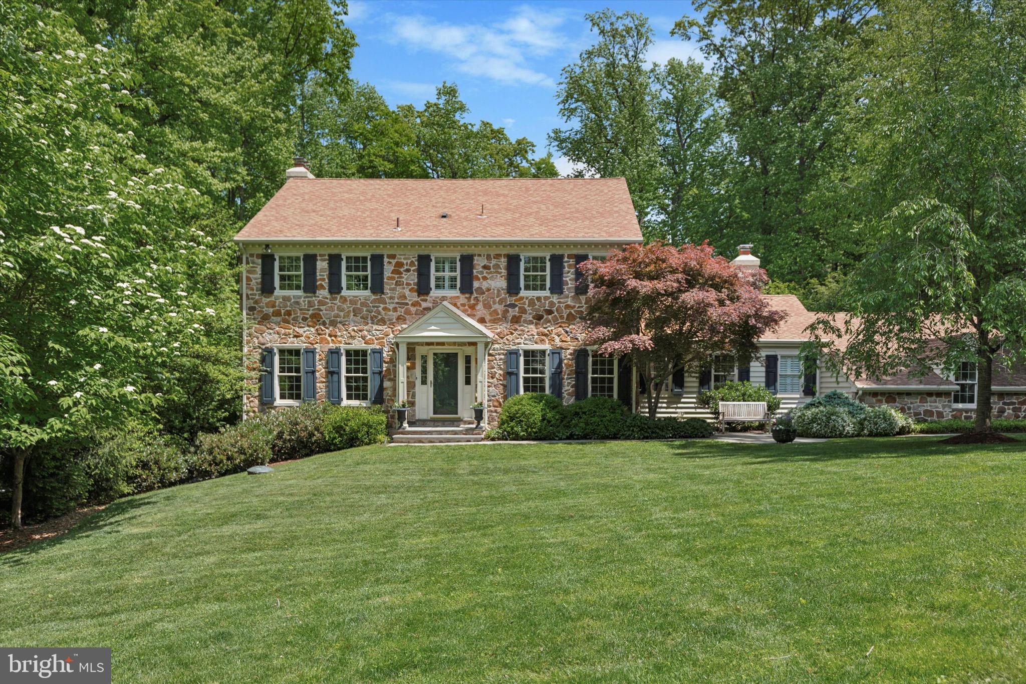 Looking for a house that makes you say, “Wow!”? That’s what you get with 553 Tanglewood. This impeccably maintained, thoughtfully renovated peaceful oasis in the highly sought-after T/E School District offers everything you’ll need and then some. Located at the end of a quiet cul-de-sac, this beautiful stone Colonial sits just off the street, but tucked behind a canopy of trees, giving you the ultimate privacy while still being centrally located. The home boasts over 5,500 square feet of living space anchored by a gourmet kitchen with custom inset cabinets, two islands, a 6-burner Wolf Gas Range, Sub-Zero Refrigerator, and Miele Dishwasher. While there is island seating and an eat-in kitchen area, French doors separate the kitchen from a formal dining room. The kitchen opens into the family room and a sitting room bathed in natural light. The view of the backyard will immediately draw you outside. No expense was spared in creating this elegant and versatile outdoor space with an expansive bluestone patio that wraps all the way around a gorgeous swimming pool (all the outdoor furniture is included with the sale of the home). On the main floor, you will also find a large mudroom, laundry room, and half bath, as well as a living room and office/den, which could potentially be converted into a first-floor primary suite. The second floor is where you’ll find the primary bedroom and renovated ensuite bath with radiant floor heating. There are three additional bedrooms and a full bath on this floor as well. On the third floor is an additional bedroom and full bath, as well as three walk-in attic storage areas. Once you get to the lower level, you’ll wonder if the house just keeps on going. There is 1,608 square feet of finished space providing numerous options. Here you’ll find another bedroom with large walk-in closet, kitchen complete with granite countertops and a double oven, full bath with radiant floor heating, and laundry room. There is enough additional space for a den, gym and even an office, with a built-in desk and cabinets. A separate entrance to the lower level can be found off the back of the house. Additional “extras” that come with the house include a whole house generator, surround sound in the family room and outside, separate propane tank to heat the pool, and an abundance of storage space throughout the home.