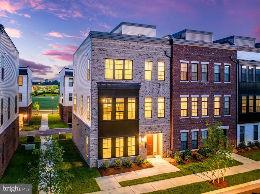 Experience true luxury in the heart of Regency at Belmont, Toll Brothers' only active adult 55+ elevator townhome community! Situated on a premium upgraded lot, tucked away from the hustle and bustle of roads, this nearly new End-Unit contemporary retreat offers the perfect blend of modern elegance and careful craftsmanship, including three fully en-suite bedrooms, gracious open-concept living areas, and views from your private rooftop terrace. As you arrive inside, you are greeted by wide-plank hardwood floors that flow throughout the home, creating a light and airy ambiance. The formal entry opens to a generous foyer, introducing the home's modern style of light wood and neutral hues, inviting serenity and relaxation. The first level features a well-appointed bedroom suite filled with natural light, complete with a large walk-in closet and an en suite full bathroom with an oversized step-in shower. Your own private elevator awaits to effortlessly whisk you up to the living spaces, bedrooms, and roof terrace above. On the second level, an expansive open-concept great room blends your gourmet kitchen, living, and dining areas into one ultimate destination. The kitchen boasts a large island with breakfast bar seating, perfect for hosting lively cocktails and conversation or an intimate casual meal. No expense has been spared, from the suite of high-end upgraded KitchenAid appliances to the countertops, backsplash, and brushed-nickel hardware found throughout the home. Unleash your inner chef with a vast walk-in pantry stocked with your favorite ingredients. A powder room is thoughtfully placed near the stairs for added convenience. Retreat to the third level, where your lavish primary bedroom awaits with views over the community. Enjoy ample storage with a sizable walk-in closet featuring upgraded organizer shelving. The luxurious primary bath offers spa-inspired finishes, a spacious step-in shower with built-in seat, and a chic double-sink vanity. A second bedroom on this level features a large walk-in closet and another private en suite bath. The large laundry room, complete with a sink, storage, and upgraded Whirlpool front-load washer and electric dryer, makes household chores a breeze. The fourth level is a true oasis, featuring a roof terrace with a gas fireplace that greatly expands your outdoor living area. Enjoy sun and treetop views from this beautiful vantage point, all easily accessible from the elevator on any floor. This level also houses your HVAC and water utilities, tucked away from the living areas and bedrooms to enhance your peaceful seclusion. The two-car garage offers the ultimate in convenience, with a 220-volt EV charging outlet, finished epoxy floors, exterior keypad entry, and plenty of extra storage. The home's smart amenities include a comprehensive security system with glass-break and window-contact sensors on the first level, foyer motion detection, and an extra security panel in the primary suite for your total peace of mind. Experience top-speed internet throughout the home with installed coax and CAT6 outlets in the great room and bedrooms, and a cutting-edge EERO WiFi6 networking package for effortless access wherever you are. Regency at Belmont offers an unparalleled lifestyle, located next to Belmont Chase shopping center for easy access to Whole Foods and a variety of highly rated restaurants and shops. The community features a pavilion and pickleball court for active lifestyles, and owners may also join Belmont Country Club Social HOA amenities, including a gym, pool, and tennis access, for an additional monthly fee. Don't miss this opportunity to embrace a life of luxury, convenience, and style in one of the most sought-after active adult communities!