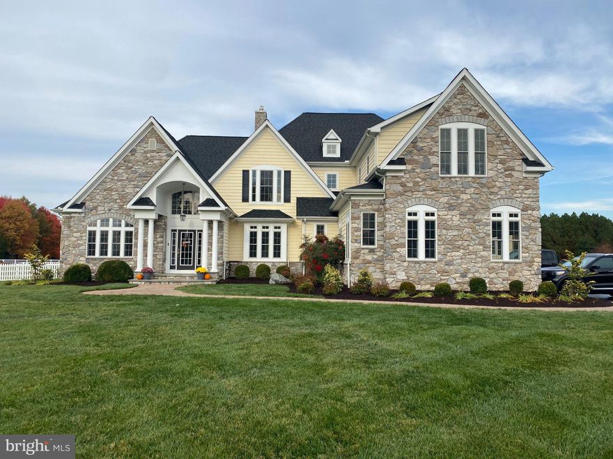 Experience a true “wow” moment the instant you arrive at this meticulously maintained estate in the exclusive Bennett Point community, set on a private street with sweeping views of the renowned Wye River.

Step into the grand foyer and be greeted by soaring ceilings, elegant columns, lighted niches, graceful arches, and a stunning curved staircase. The home opens into a formal dining room perfect for entertaining, flowing seamlessly into a dramatic two-story family room with a wall of windows overlooking the patio, saltwater Gunite pool, fenced backyard, and barn.

A floor-to-ceiling stone gas fireplace anchors the space—ideal for cozy winter nights or gathering for the big game. The open-concept layout continues into a chef’s dream kitchen, featuring granite countertops, abundant Merillat Masterpiece solid cherry cabinetry, and premium appliances including a Sub-Zero refrigerator/freezer, commercial-grade Viking cooktop with hood and pot filler, double wall ovens, built-in microwave, beverage cooler, dishwasher, and trash compactor. A spacious island, built-in desk, appliance cabinet, hidden cutting board, and corner pantry make this kitchen as functional as it is beautiful.

The main level offers two luxurious owner’s suites. The primary suite includes a wet bar, private sitting area, dual walk-in closets, and a spa-inspired bath with heated soaking tub, dual-head shower, travertine floors, and marble countertops. The second suite features a gas fireplace, built-in desk, and an accessible ensuite bath with roll-in shower and elegant finishes—ideal for multi-generational living or guests. A main-level laundry room adds everyday convenience.

Throughout the home, you’ll find rich teak flooring, tray ceilings, and abundant recessed lighting. Upstairs, three spacious bedrooms each feature private ensuite baths, along with a large game room. A generous unfinished third level offers endless possibilities for expansion, including an au pair suite or additional bedrooms.

Outdoor living is equally impressive. Enjoy the fenced saltwater pool with water feature, a screened porch with Easy-Breeze windows for year-round use, and a beautifully maintained yard with underground irrigation, vegetable garden, and whole-house generator. The conditioned crawl space adds efficiency and peace of mind.

Equestrian enthusiasts will appreciate the adjacent horse training facility with covered arena. The property includes a 3-stall barn with heat sensor, two pastures, dry lot, heated water, electric, and vinyl fencing—perfect for year-round care and riding.

This exceptional property offers luxury, functionality, and lifestyle—all in one remarkable setting.