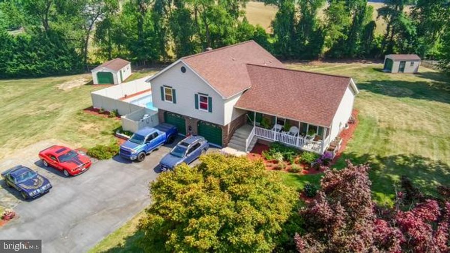 Nestled on a lush 1.05-acre lot, this inviting 4-bedroom, 2.5-bath tri-level home offers both comfort and charm. The beautifully landscaped grounds are complemented by a covered front porch and a mid-level walkout leading to a fenced in-ground pool, perfect for summer gatherings. Inside, the spacious primary bedroom provides a serene retreat, while the upper-level laundry adds convenience. The lower level is an entertainer's dream with a bar and pool table. Move in ready and awaits your personal touch to bring it to its full potential.  Acces pool thru garage. Code is on the door. Patio door replacement is on order.  Square footage was pulled from the tax records and have not been verified.