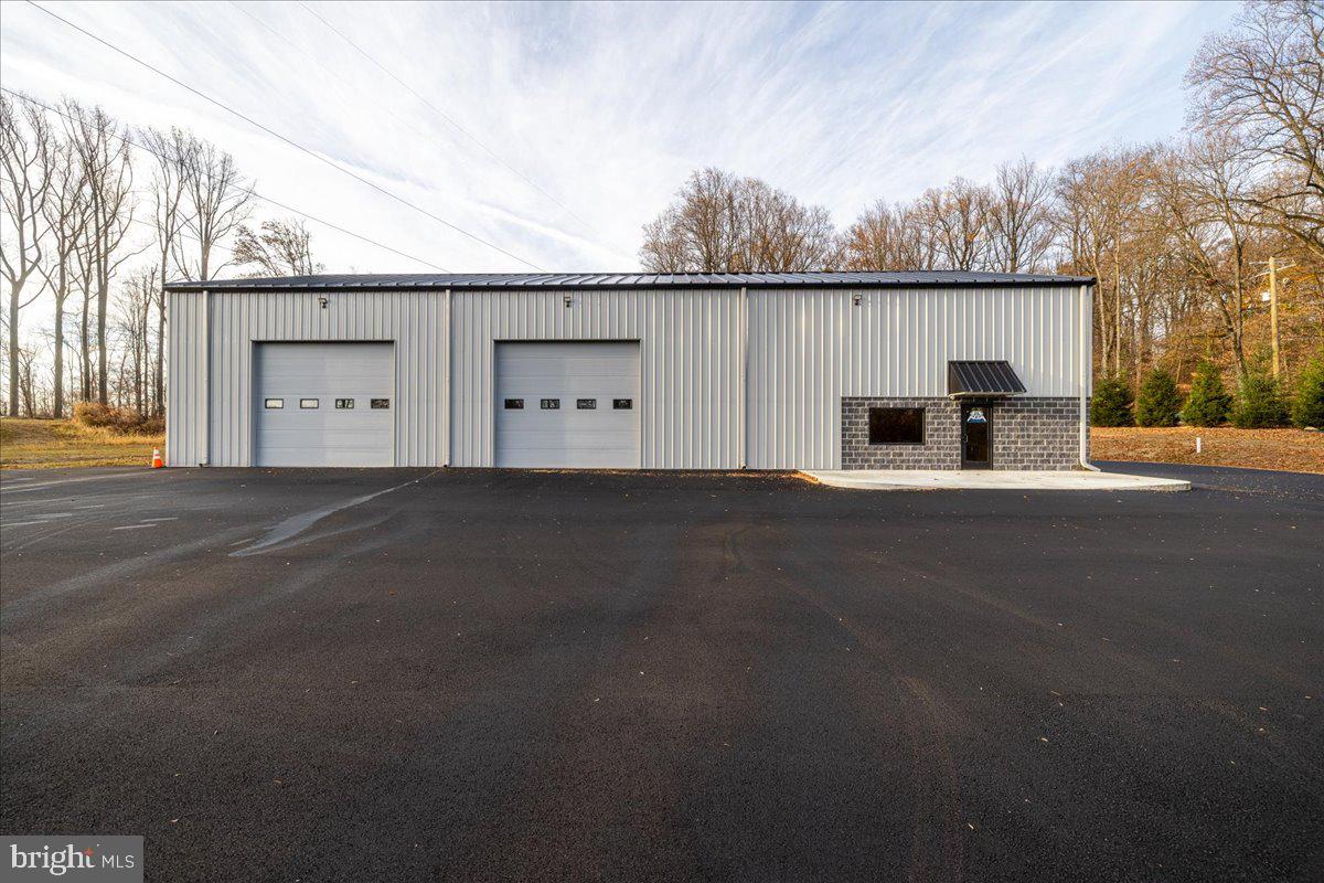 Introducing a brand-new, 5,000-square-foot warehouse designed to meet the needs of many types of businesses. The warehouse boasts four 14-foot drive-in doors, 20+ foot high ceilings for ample vertical storage, a utility room/break room with a sink and ADA bathroom, an enclosed office area on the upper level, and additional storage space to support a range of operational needs. The office layout includes a waiting area for greeting clients, three spacious private offices and a dedicated conference room for meetings and presentations, complemented by a well-equipped kitchenette for added convenience and a second ADA bathroom. Don't miss the opportunity to elevate your business in this thoughtfully designed, move-in-ready property.