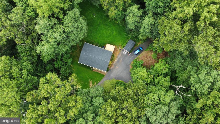 Have your buyer agent schedule your showing quickly, this property won't last long.   New deck and new roof put on in the last 30 days.  Check out the amazing location.

Welcome to 836 Wilda Drive, a beautifully kept 3-bedroom, 2-bath split foyer home set on a private, park-like lot in a walkable neighborhood. From the moment you arrive, the long driveway offers privacy and plenty of parking options, including a side parking pad for large vehicles or a boat, space near the shed, and room to accommodate gatherings of up to 20 cars. The exterior shines with a new roof, a freshly built deck, and a storage shed, all surrounded by mature trees and daily visits from deer.

Step inside to an oversized foyer with like-new hardwood floors and a bright, open feel. The main level features a dining room large enough for a full table, an updated kitchen with L-shaped layout, and color body porcelain tile flooring that is more durable than standard ceramic. Upstairs you’ll find three generously sized bedrooms, including a private owner’s suite with its own bath, plus a hall bath and convenient closet storage. The finished lower level walk-out offers extra living space with a rough-in for an additional bathroom under the current flooring, while the unfinished utility area adds plenty of storage.

This home has been thoughtfully cared for with important upgrades, including a 2015 HVAC system, a 2021 well tank still under warranty, a new water heater in 2012, upgraded plumbing from copper to PVC, and gutters with leaf filter attachments. The septic system is maintained regularly with cleanings every two years.

Enjoy the peaceful setting from your deck or patio while feeling tucked away in nature, yet close to everything. Just minutes from Deer Park, Liberty Reservoir, and Piney Run Park in Sykesville—known for award-winning smallmouth bass fishing, kayaking, and boating—you’ll have endless outdoor activities at your fingertips. The YMCA and Mechanicsville Elementary School are also nearby, adding to the convenience.

This is a turnkey, well-kept home where you can move right in and enjoy stress-free living in a beautiful, nature-filled setting.