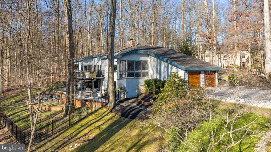 Nestled on over three private acres, this stunning five-bedroom contemporary home is a true woodland sanctuary. Surrounded by lush greenery, the property offers both seclusion and captivating natural beauty, creating the ultimate private retreat.   
Step inside to discover soaring vaulted ceilings with exposed wood beams, creating an airy and inviting ambiance. The spacious living and dining areas, adorned with gleaming hardwood floors, provide breathtaking panoramic views of the serene landscape. A magnificent floor-to-ceiling wood-burning fireplace stands as the heart of the great room, perfect for cozy evenings.   
Expansive sliding glass doors flood the space with natural light and lead to a massive deck that spans the length of the home—an ideal setting for entertaining or simply unwinding with nature as your backdrop.   
The gourmet kitchen is a chef’s dream, featuring dual Wolf ovens, a Sub-Zero refrigerator, a Cove dishwasher, and sleek quartz countertops. A charming breakfast nook with its own fireplace adds warmth to the space, while the adjacent screened porch provides a peaceful retreat for outdoor dining, making every meal feel like a mountain getaway.   
The main-level primary suite is a true escape, complete with a private ensuite bath and direct access to the deck, blending indoor comfort with outdoor serenity. Two additional spacious bedrooms and a full bath complete the main level.   
A lofted second floor offers additional space for storage, a reading nook, or a private workspace. The fully finished lower level provides even more versatility, with two additional bedrooms, a full bath, and a large recreation room with a walkout to the wooded backyard—ideal for guests or a private retreat.   
This exceptional property features a two-car side-load garage, stunning seasonal views, and an architectural design that perfectly complements its natural surroundings. Tucked away in the coveted Woodmark enclave with voluntary HOA, this home offers the ultimate blend of luxury, privacy, and convenience. * Tax record not pulling correctly.  Estimated Above Grade sqft: 3347  Estimated Below Grade sqft: 2077.  Over $500k renovations and upgrades. 
Water heater: 2 years, Roof: 10 years, Appliances: 2 years, HVAC: 2 years