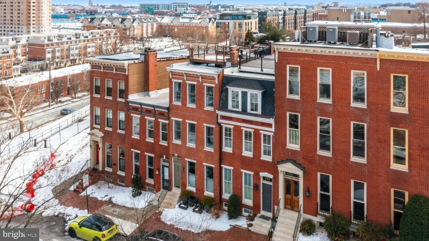​​A commanding park-front residence on one of the rare non-through streets directly across from Federal Hill Park, 409 Warren Avenue offers an exceptional blend of architectural presence, craftsmanship, and panoramic Inner Harbor views from every level. Positioned on a high promontory, this four-story all-brick Federal Hill townhome captures magnificent harbor and skyline vistas — from its multiple outdoor living spaces. Freshly painted and featuring newly stained oak hardwood floors throughout, the home presents with refined warmth and timeless elegance.

The first level welcomes you with 12-foot ceilings, a grand parlor with 3 wood-burning fireplace, and abundant natural light. The spacious dining area flows seamlessly into a gourmet kitchen appointed with granite countertops, 6 burner Viking gas range, custom cabinetry, and a breakfast area that opens to a private brick courtyard. The courtyard connects directly to the detached ​one-car garage — an exceptional amenity in Federal Hill. A dramatic three-story staircase with original treads and banister anchors the home, showcasing the craftsmanship found throughout.
The second level features the primary suite offering scale and comfort with dual closets and a luxurious spa bath featuring a soaking tub, separate shower, and double vanity. An additional generously sized bedroom and full bath completes this level.

​Designed for refined entertaining, the third floor features a cozy family room with gas fireplace, extensive custom built-ins, and a sophisticated wet bar with granite island and oak cabinetry. This level opens to the first rooftop deck with pergola — an intimate setting for sunset gatherings. Ascend one level higher to the expansive, rooftop terrace​, from here, enjoy sweeping views of the Inner Harbor and Baltimore skyline — a truly extraordinary vantage point.
The finished lower level offers a private bedroom with full bath, laundry room, and utility/storage areas. 
The home is equipped with: Elevator access from basement to third floor (Concord brand, all doors must be closed to work properly), two HVAC systems replaced in 2018 ( located  on the basement and closet on half bath 3rd floor) , 3 AS IS wood-burning fireplace (main level)​, gas fireplace (third level)​, water heater replaced in 2016​, additional insulation on the second floor​, custom built-ins and storage on every level.  One car garage, luxury Viking stove, subzero fridge. Located steps from Federal Hill Park and moments from Cross Street Market, this residence offers immediate access to farmers’ markets, festivals, boutique shops, coffee houses, restaurants, the promenade, marinas, stadiums, and museums. Urban living here is vibrant, walkable, and deeply connected to Baltimore’s waterfront energy.