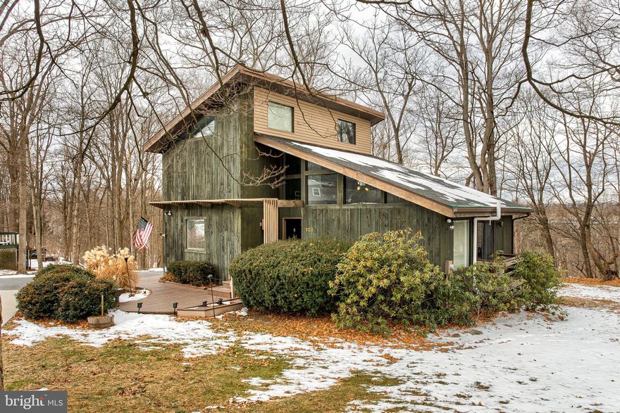 A stylish modern retreat on "The Hill" in Boalsburg. This unique contemporary home includes soaring vaulted ceilings, and an abundance of natural light, all nestled on a spacious lot backing up to private woods. The inviting living room, with tall ceilings and large windows creates a bright, airy atmosphere flowing into the dining room, with its vaulted ceiling and hardwood floors, and wooded views. On the main floor, you'll find two bedrooms and a full bathroom, providing ideal first-floor living. Upstairs, the loft space serves as an office or play area. The upper level also features two more bedrooms and a second full bath, complete with honeycomb tile floors and a skylight. The finished lower level boasts a spacious family room—perfect for movie nights or game days—and a large office/workout space/ or bedroom with easy walk-out access to the back yard. A third full bath has also been recently added to the lower level as well. Outside, relax on the back deck or in the hot tub. An EV charger is ready for your electric car, and the home's southern exposure makes it an ideal candidate for future solar panels. Recent upgrades include a newer roof, newer HVAC, and top of the line tankless water heater. Conveniently located near the Village of Boalsburg, with shops, a brewery, cafes, a park, schools, as well as easy access to Penn State, and Downtown State College.