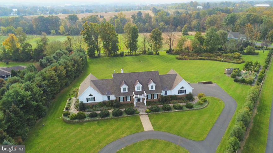 This idyllic retreat in pastoral Springfield Township was thoughtfully designed and built by the current owners in 2007. Although the bucolic surroundings feel like you're a world away, the location is actually just minutes from the Lehigh Valley, NJ and I-78.  One of only ten properties, the 3.3-acre parcel is privately sited on a cul-de-sac and backs to 26 preserved acres cultivated as a farm and vineyard.  A circular drive is the inviting entry to a classic front portico embellished by specimen plantings, rare boxwood, and stone walkway. Flanking the foyer are formal LR and DR set off by unique bi-fold French doors with transoms.  A separate wing comprises the lush master suite -- truly an oasis for tranquil repose with tray ceiling and accent lighting, window seat, many windows and a door to the covered porch.  The master bath has a heated tile floor, vaulted ceiling, Jacuzzi tub, double vanity with marble counters, steam shower with seamless doors, bidet, and Kohler fixtures.  Two main-floor offices offer convenient work-from-home opportunities.  In the opposite wing, a full guest suite includes a bathroom with ADA features, imported tile, and floor with radiant heat. The comfortable FR opens to a well-appointed kitchen that entertainers and gourmands alike will relish, with mostly GE Monogram appliances and Bosch dishwasher.   Beautiful custom red birch cabinetry continues into the butler's pantry with wine frig.  Two additional generous bedroom suites and second LR/FR room complete the second floor, and multiple ground-level windows and doors naturally light the full walk-out basement, with extra height for future 9-foot ceilings if finished.  Imported tile, hardwood floors, radiant heat in the two main bathrooms, whole-house sound, two fireplaces, steam shower, and back-up generator are just a few of the noteworthy features of this one-of-a-kind property. Add to this a serene exterior brimming with natural beauty from gardens full of specimen and native plants.  A maintenance-free covered porch and deck span the rear of the home, where breathtaking views of vineyard, sunsets, farms, and wildlife provide a soothing retreat.  Only 10 minutes from Hellertown and Coopersburg, 15 minutes from the Promenade Shops, and 75 minutes from NYC.  An unparalleled combination of understated sophistication, convenient location, coveted privacy, and exceptional appointments inside and out.