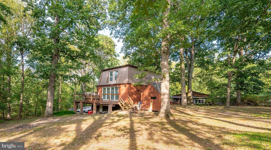 Mid Century Modern style- on a wooded , half acre lot just outside of  historic Harpers Ferry.     Enjoy the peaceful setting and wildlife while relaxing   on the wrap around  deck.  House features open main level floor plan  including kitchen,  food prep/pantry room, dining room, large family room,  2 new windows  and updated half bath. The upper level  includes 3  physical bedrooms  (2 bedroom septic) and  updated   full bath. There is a wall safe in one of the primary closets. The insulated basement provides a  one car garage space , garage opener,  mini split, and  full bath.  On  the main and upper levels, seller started improvements but is not able to complete the floor and wall renovations.  A blank canvas that you can complete  with your design!  But house offers  newer mechanicals- water heater, HVAC , electric panel with surge protector,  whole house water filters,  and UV light .  Septic pumped 2020.      Shed conveys . Xfinity internet goes to house.  Property sold  AS IS.  Reasonable Offers considered. 
Community has private access to Shenandoah River and pool membership  for additional fee.  Light restrictions.  Short term rentals allowed in community.  Use as full time residence or vacation home .  Area offers many outdoor recreational activities  and historic venues to enjoy!