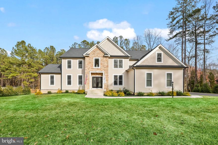 Community Open House this Saturday, March 15th 1pm -4pm. Welcome home to this two year old, custom-built home by JOHN ROBB Custom Homes in the desirable Fawn Lake Community. Luxury meets comfort in this 4200+ finished square feet home plus an additional 2200+ unfinished square feet in the basement. Stunning architecture and no details were overlooked in the craftsmanship of this home. Boasting elegant trim work and rounded corners throughout this inviting and extraordinary home. Situated perfectly on 1.44 acres, you are surrounded by mature landscaping with winter views of the lake and golf course.  You are first greeted by the two story foyer, elegant LVP flooring, and tons of natural light. Entertain and relax in the front sitting room and dining room where there is plenty of room for family and friends. The two story family room draws you in with it's coffered ceiling with modern light fixture, floor to ceiling stone fireplace, and magnificent views of the tree lined backyard. The chef-inspired kitchen features quartz countertops, upgraded cabinetry with soft close drawers and lighting underneath the cabinets, dual wall ovens, six burner gas cooktop with griddle and a wall mounted pot filler above it, side by side column refrigerator and freezer, farmhouse sink, built-in wine fridge, an island that seats four comfortably, walk-in pantry with pocket doors, and kitchen table space with continued views of the backyard and access to the deck for grilling and entertaining. One of the homeowner's favorite areas is the new enclosed sunroom with a mini-split and two flush mount ceiling fans that allow you to enjoy this room year round. Walkout on the 30 foot long deck from here to continue the peacefulness of the area. There are two bedrooms on the main level that are connected by a full bathroom. This makes for a great guest suite or for anyone who doesn't want to use the stairs. A laundry room with a dog shower area  and half bathroom complete the main level. Make your way to the upper level where there are four generous-sized bedrooms including the magnificent primary bedroom suite. This is your personal retreat with a spacious sitting area, an envious size walk-in closet and another closet perfect for shoes! This primary bathroom is your spa-like experience. The frameless, walk-in shower has dual shower heads, the garden tub sits perfectly with a picture window allowing in the natural light. One of the other bedrooms has its own ensuite bathroom and views of the backyard. The other two bedrooms are connected by a Jack and Jill bathroom. Looking for more room to expand? The unfinished basement is ready for you to finish the way you like - an egress window for a future bedroom, roughed-in for a future full bathroom, wet bar or kitchenette, and another laundry hookup. Currently, it makes for a convenient gym. Walkout on the patio for more areas to relax. This opens up to the fenced-in backyard that has two double gates on either side of the house and a single gate at the rear, which provides access to the creek and the remaining portion of the property on the other side of the creek. The backyard has tons of room for backyard activities including a future pool. The property goes past the rear fence and includes a resource protection area. Three car garage with huge driveway.  NEW improvements include the enclosed sunroom, whole house generator, solar panels, and rear fencing. There are even outlets in the soffits so you can hang your holiday lights! Irrigation system keeps your yard looking beautiful! The builder's structural warranty is transferable to the new owner. Fawn Lake is rich in it's amenities including the lake and marina, Arnold Palmers' designed golf course, clubhouse with pool, fitness center, and so much more. Welcome to Fawn Lake living!