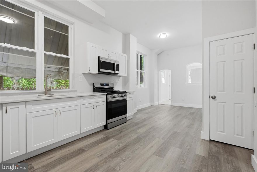 Welcome to a beautifully updated residence in  Philadelphia, where classic character meets modern comfort. From the moment you enter through the vestibule, you are greeted by an inviting first floor featuring very high ceilings, recessed lighting, and sleek laminated flooring that flows seamlessly throughout the main living areas. The kitchen has been thoughtfully upgraded with quartz countertops, white shaker cabinetry, and a full appliance package including a gas range, built in microwave, and refrigerator. Tall windows bring in an abundance of natural light, creating a bright and airy atmosphere, while a convenient pantry adds extra storage. Toward the rear, you will find a dedicated laundry area and direct access to the fully fenced backyard, offering a private outdoor space ideal for relaxing or entertaining. A powder room on the first floor adds everyday convenience. The fully finished basement expands the living space and features laminated flooring along with a versatile BONUS ROOM that can be used as a home office, gym, or additional living area. Upstairs, the second level offers three well sized bedrooms, two of which include ceiling fans, along with a hallway bathroom featuring a tub shower combination. The primary bedroom serves as a comfortable retreat with its own private bathroom complete with a shower stall. Natural light continues to pour into the upper level, enhancing the warmth and livability of the home. Ideally located near local shops, public transportation, and major roadways, this move in ready home offers both style and convenience in a rapidly developing area of Philadelphia. Schedule your showing today