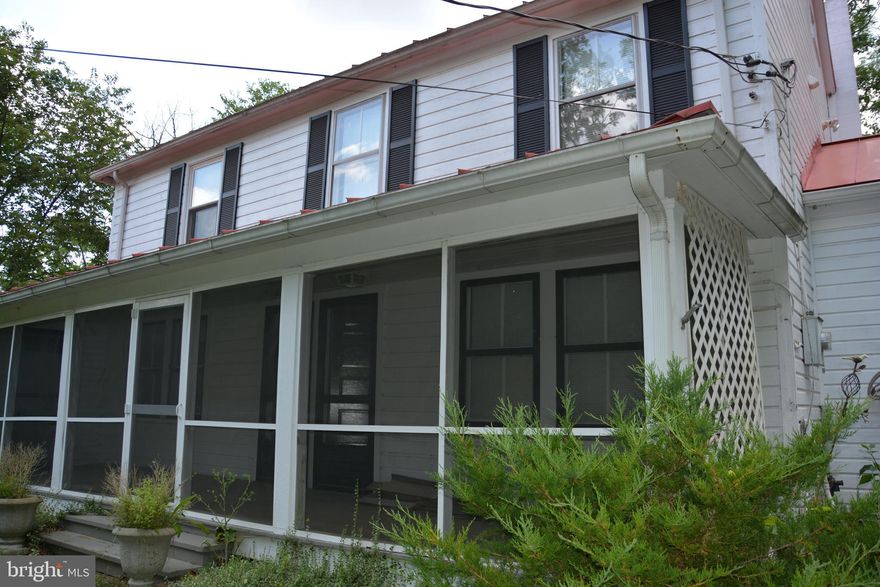 What a neat find.  This vintage farmhouse with extensive updating is situated on just under an acre within the town limits of Capon Bridge, WV.  The rooms are all quite spacious with painted hardwood floors throughout.  Three bedrooms (two have large closets) three full baths (two on the main level).  There is a dressing room between the two largest bedrooms that gives direct access to the rear upper level, screened porch.  The upstairs level has central air conditioning.  The main level has a nice sized kitchen with a separate laundry.  There is a formal dining room with direct access to the front screened porch.  The living room is also quite spacious with access to a long sunporch with upgraded windows.  This main level also has two full baths.  The home is in great condition.  Thinking in terms of an AIR-B&B, or potentially a weekend getaway, don’t miss seeing this one.  The land has 6’ perimeter fencing and a gated entrance.  There is a small creek running through the property.  Most of the land is virtually maintenance free due to topography.  There is hardscaping and rock gardens along with a barn style shed and a smaller tool shed.  The property is serviced by Town Water and Sewer, eliminating any potential problems with well or septic.  The furnishings do not convey with the sale.