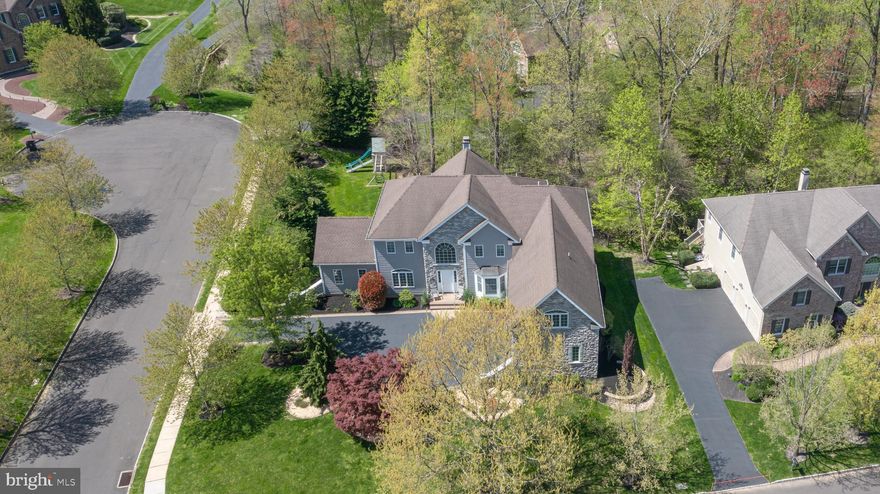 An exceptional corner and cul de sac property nestled in Upper Mountain Estates brags of striking curb appeal with its remarkable blend of unique exterior textures and finishes while offering the perfect combination of community and seclusion. Nestled in a quiet and highly desirable neighborhood, this amazing home harmonizes inviting warmth, with a modern floor plan benefitting from light hued hardwoods, 10’ ceilings and elegantly rendered millwork. An abundance of natural light and openness surround you in the impressive 2-story foyer adorned with a gracefully turned staircase flanked by the wainscoted formal living room with extensive moldings and dining room decorated with a stylish tray ceiling and triple-pane bay window. Utilized in numerous ways, the neighboring conservatory is a notable space with its three walls of windows and grand vaulted ceiling. The centerpiece of the home is the gourmet kitchen and certainly a chef’s delight with its oversized island with seating, granite counters and a suite of high-end, stainless-steel appliances including a Viking range and oversized Sub-Zero refrigerator. The breakfast nook offers convenient access to the rear deck and leads seamlessly to the open, 2-story gathering room with second floor overlook where friends and family can gather around the cozy wood-burning fireplace on chilly evenings, creating the perfect ambiance for relaxation. French doors overlooking the backyard oasis border the fireplace allowing for a pleasing flow making this room ideal for any size gathering.  Completing the main level is a sizable home office, half bath, custom kitchen pantry plus dining room server area and laundry/mud room. Upstairs features the primary suite with an eye-catching tray ceiling, sitting area/den, and large walk-in closets. Indulge yourself in this main bath highlighting a Jacuzzi tub, oversized walk-in shower, and dual vanities. A spacious ensuite bedroom can also be found on this level as well as two other bedrooms which share a convenient Jack and Jill bath. Downstairs, the finished lower level offers additional living space including a full bath, bedroom, theater, billiards/game room, craft room and ideal storage. Located in the in the award-winning Central Bucks School District and perfectly located to all the entertainment and dining New Hope, Newtown, and Doylestown have to offer; not to mention Lookaway Golf Club right around the corner and minutes to Peddlers Village. Enjoy the peaceful wooded trail for exercise and dog walking amongst beautiful mature forest and unique geology. This setting cannot be beat!