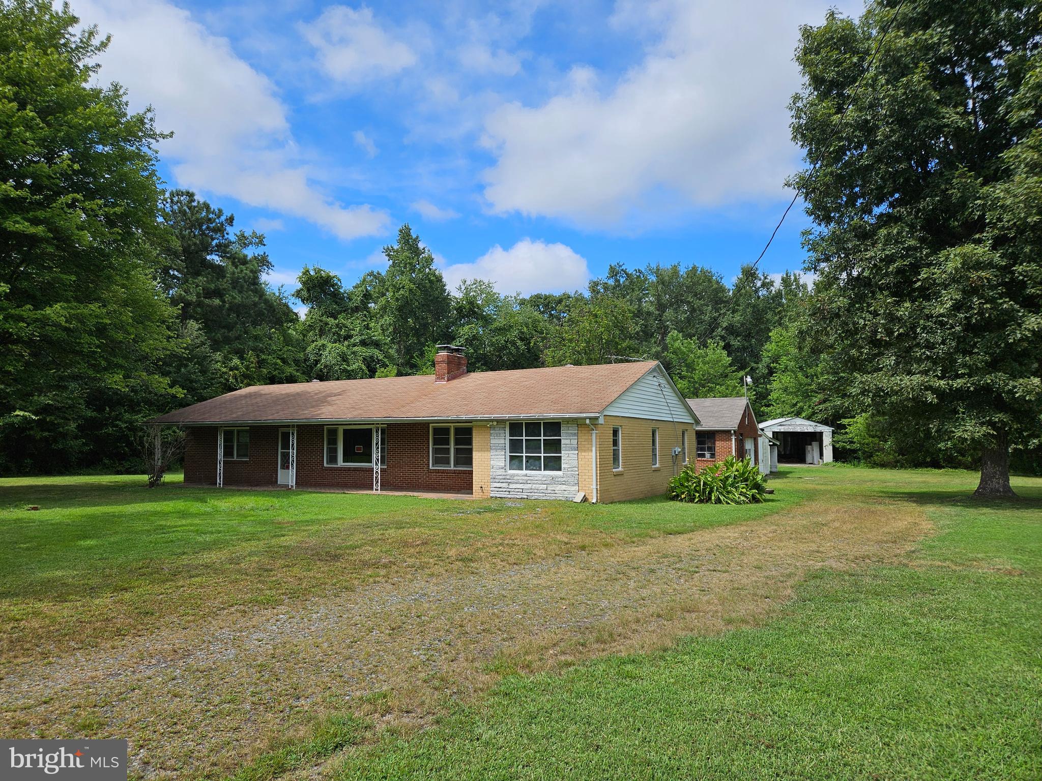 Work and save!!! Enjoy the peace and quiet that this 2.41 +/- acres offers. Fronts on a major secondary road. Only about 5-6 miles from I-95 at Kings Dominion. Approximately 1/2 mile off of Rt. 301. Close to Rt. 1 also Close to Hanover Courthouse area. Verify schools and tax information. Split Bedroom design. Wood burning fireplace with floor to ceiling brick hearth. Wood-stove insert on the other side with floor to ceiling brick hearth. Covered front porch. Brick and stone exterior. Heated Detached garage, shed, lean to with concrete flooring. Second cinder block building that was used for a large boat storage, also with concrete floor. Vegetable sink in the laundry room. Newer hot water heater. Oil furnace has had regular servicing. Stainless refrigerator and gas range in the kitchen. There is an extra mini refrigerator in the laundry room, and a full-sized refrigerator in the garage. There is a freezer in the boat storage building. There is a dryer in the garage. All appliances convey strictly as-is. Sliding glass doors out of the DR to the patio.