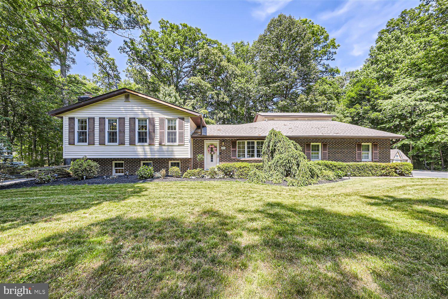 Gorgeous 4BR/4BA expanded split ranch on a sprawling lot in the desirable neighborhood of Finksburg. As you make your way to the front door of your forever home pass by lush green lawns and manicured landscaping. Step into the first of three floors of beautifully maintained living space featuring hardwood flooring beginning in the large living room beaming with natural light, and a music room leading to an oversized kitchen. Enter the kitchen passing by two walls of pantry closets and double wall oven, then turn the corner into a stunning kitchen with tons of custom cabinets, granite countertops, beautifully tiled backsplash, and an oversized island with seating. A large formal dining room is just off the kitchen boasting chair rail moldings and a brick fireplace. A grand family room makes for the ideal entertainment space. A spiral staircase takes you to an in-law/guest suite with an efficient kitchen/laundry, a full bath with a walk-in shower, and a private entrance. Just past the kitchen is the main floor laundry room with access to the two-car garage. Upstairs is a large primary suite complete with a private ensuite featuring a double sink vanity and large soaking tub. Two sizable bedrooms and a full bath completes this floor. The lower level offers the fourth bedroom with a full bath featuring a walk-in shower, a wall of brick with a wood burning stove insert, a playroom, a wet bar, and stairs to a sub basement offering additional living/storage space. Step out from the main floor family room to a yard filled with beautiful hardscaping and landscaping. The grand patio features a raised brick wall that overlooks an abundance of green space, adult shade trees and forest like surroundings. This home is move-in ready and has so much to offer new homeowners. Imagine all this and in close proximity to shopping, restaurants, and commuter routes.