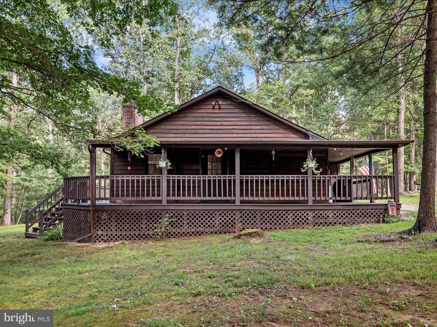 Nestled in the serene Cove Mountain Estates, this charming cabin-style home offers a perfect blend of comfort and nature. With 3 spacious bedrooms and 2 full bathrooms, the open floor plan invites warmth and togetherness, you will find unique eucalyptus floors that wow as you enter the home. The heart of the home features a country kitchen with Hickory cabinets and an island, seamlessly connecting to the family room, where a cozy brick fireplace awaits for those chilly evenings. Enjoy the convenience of a main floor laundry and a walk-in closet in the primary suite, enhancing everyday living. Seller has not had Fiber Optic Internet service installed and currently uses DSL. High Speed Fiber Optic internet service available to install! Step outside to discover 6.35 acres of enchanting landscape, partly wooded and level, providing a tranquil retreat. The wrap-around porch and expansive deck are perfect for morning coffee or evening gatherings, while the outbuilding offers additional storage or creative space. The property backs to lush trees and a gentle stream, ensuring privacy and a peaceful ambiance for chilly nights by the outdoor fire pit/BBQ pit. Located in a vibrant community, residents benefit from well-maintained roads and easy access to local parks and recreational areas. The neighborhood fosters a sense of belonging, with friendly neighbors and a welcoming atmosphere. Nearby schools and public services enhance the convenience of daily life, making this home not just a place to live, but a place to thrive. Experience the beauty of nature and the comfort of home in this delightful property. Only 15 minutes from local dining. Only Approx 3 miles from the WV/VA line with quick and easy access to Interstate 81. **Ownership in this development gives residents access to GWNF with a ROW  through Lot 7.