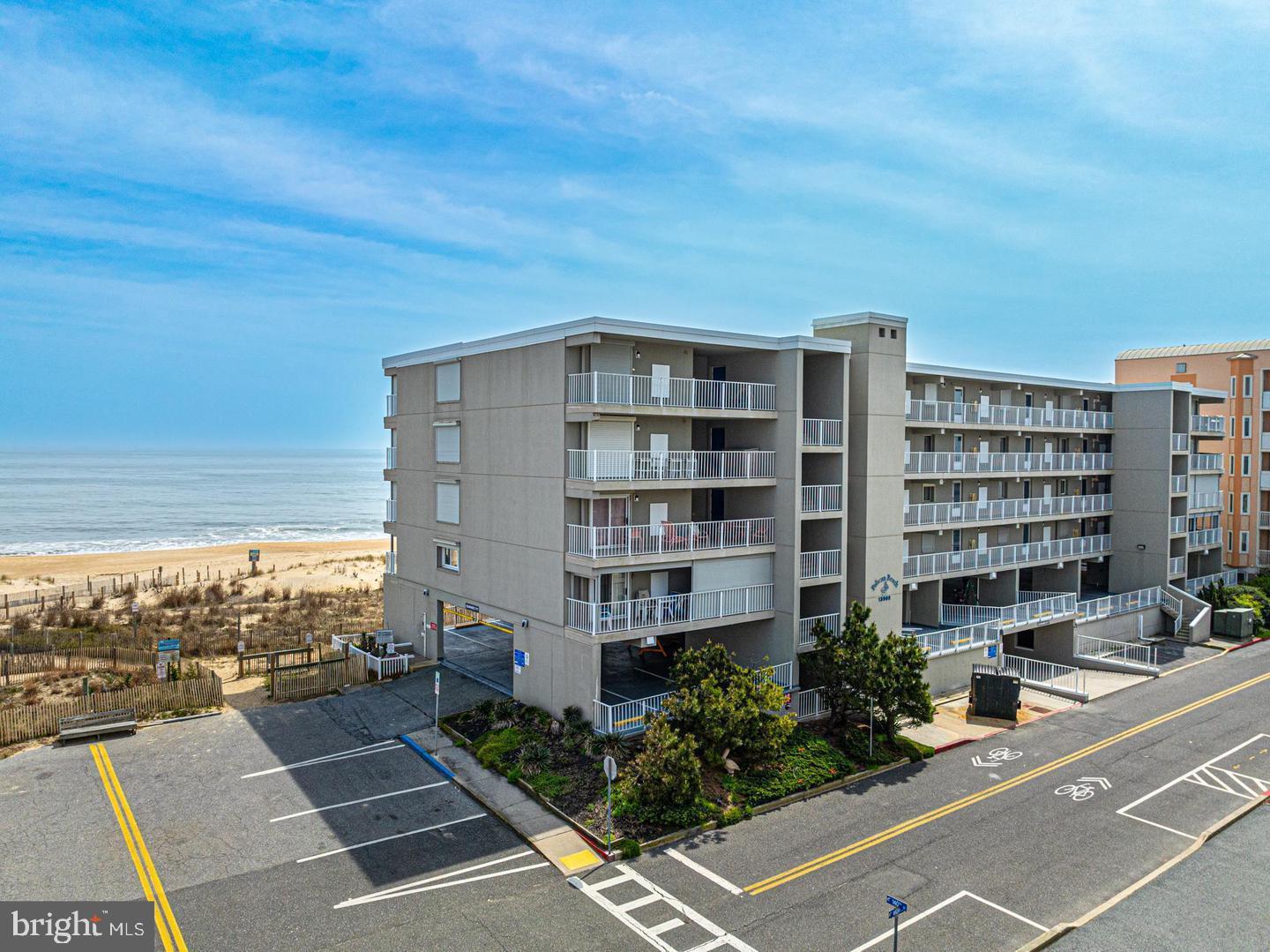 Welcome to this rarely available north-end, direct oceanfront unit in the highly sought-after Pelican Beach — a well-maintained, mid-rise masonry building in North Ocean City near the Delaware line. This spacious 3-bedroom, 2-bath condo offers a unique private entrance leading to the west-facing bayside balcony, perfect for storing bikes, beach gear, and relaxing in your own secluded space. On the other side, soak in panoramic views from the oceanfront balcony that stretches up and down the shoreline. Inside, the open-concept floor plan maximizes natural light and delivers stunning ocean views from nearly every angle. The oceanfront primary suite features private balcony access, generous closet space, and an en suite bath. Two additional bedrooms are thoughtfully situated on the west side for added privacy. Pelican Beach is a low-density building with just 28 units and an expansive beach area, giving you and your guests plenty of space to relax and enjoy the sun. Covered parking, elevator service, completed reserve study, and excellent professional management provide peace of mind for owners. With dining, shopping, and entertainment all within walking distance, this is your opportunity to own a slice of paradise in one of Ocean City’s most desirable buildings. Don’t miss it!