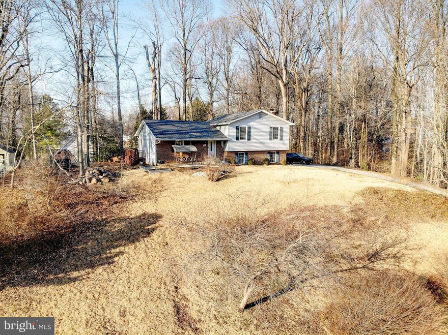 Great price for this 4-Level home with a total of 2,855 sf -- including 447 sf of unfinished storage space on bottom level!  Almost one acre (.81) of land surrounded by mature trees and in great Northern Calvert location of top-rated schools.  Kitchen has stainless steel appliances, and has real wood cabinets that a new owner could paint to easily update! Kitchen has a pantry, a breakfast bar and durable wide-plank laminate flooring.  The main level has cathedral ceilings that give the home a spacious, contemporary feel. Perfect home for entertaining-- or for family members to spread out. Has three bedrooms upstairs, including the primary suite with a renovated bathroom with a tile shower.  Downstairs, the finished lower level has a large, family room centered around a cool brick electric fireplace, along with a practical, oversized laundry area that opens to the back yard. The bonus, unfinished basement level provides excellent potential for customization—whether adding living space, a home office, gym, or just maximum storage space. The backyard is ideal for summertime fun with a huge deck for grilling and relaxing outdoors. Home has major improvements that include a newer roof and a newer HVAC system. Excellent location near beaches, restaurants, shopping and marinas. Easy commute to  Washington, D.C. and Joint Base Andrews (JBA).