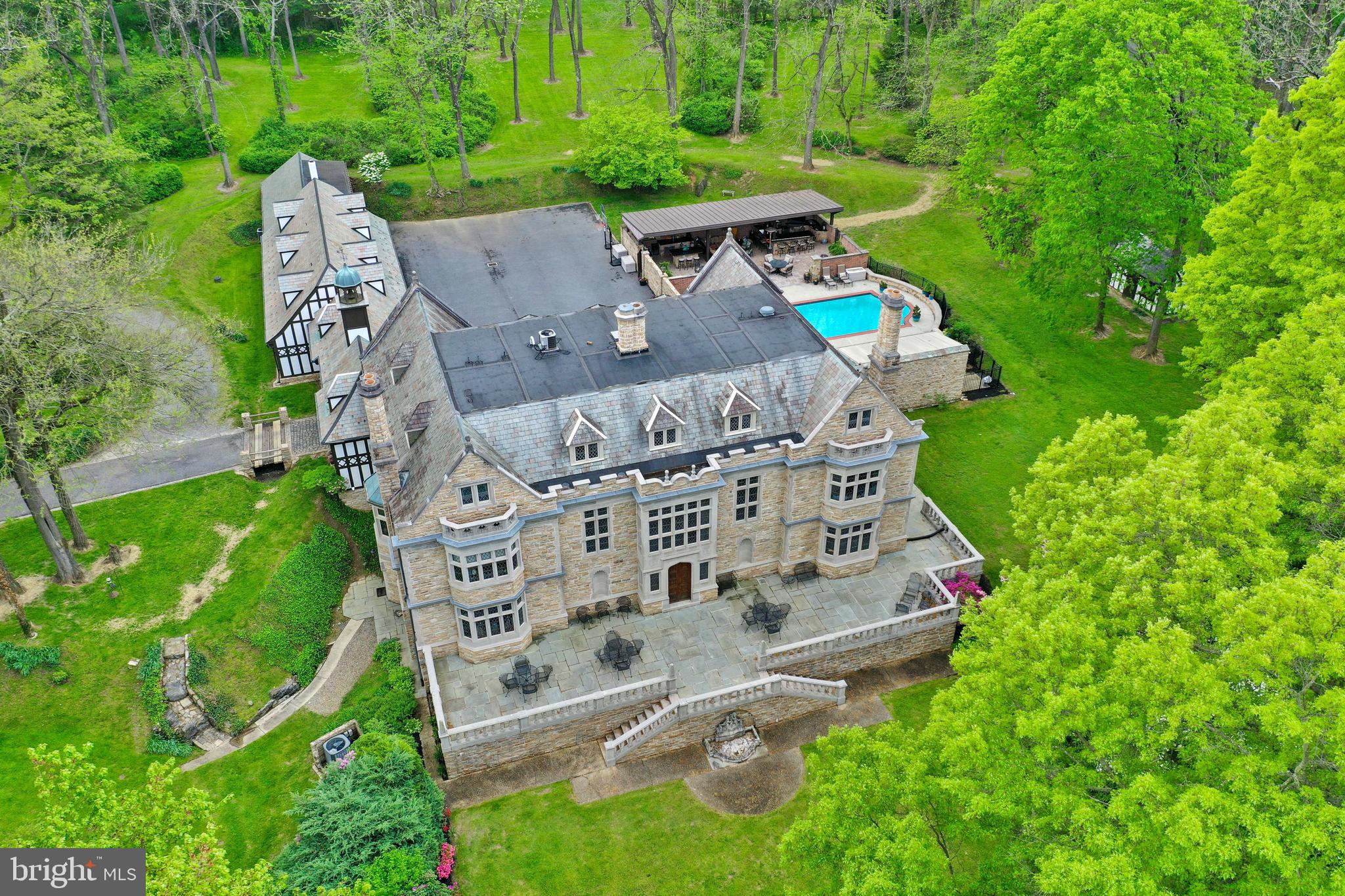 Welcome to Wyngate Manor! An elegant tree lined driveway leads to this magnificent castle-like estate that boasts 10 bedrooms, 8 full & 2 half baths, and over 10,000 square feet of living space on 4 levels. From the moment you step foot inside, you’ll feel as though you’ve been transported to England and stepped into a fairytale setting. Countless upgrades and amenities include an elevator that goes to each floor, high ceilings, marble floors inspired by the Hatfield House in England, detailed crown molding, French leaded glass windows, plaster ceilings, stained glass windows, and much more. The exterior is an absolute oasis that features an in-ground patio & pool area, a covered patio built for entertaining with multiple countertops, and a high-top bar with gorgeous hanging lights and TV. It also includes convenient access to a pool house with bath amenities. This resort-like setting is perfect for summer gatherings and relaxing under the sun at the comfort of your very own home. Also included on this property is 100 School House Rd, an income producing rental house, and a detached 6-car garage with a rented apartment on the second floor. This awe-inspiring home welcomes you with an incredible foyer that includes marble floors, detailed wood panel walls, 2-story coffered ceiling, and stairs leading up to the second floor walkway. Just off the foyer is a gourmet kitchen complete with all stainless steel appliances, exposed beams, tile floor, built ins, and pantry. A convenient laundry/mudroom is next to the kitchen and offers an ideal place to come inside after a rainy day or outdoor activities in the grass. Off the opposite side is a breakfast room designed with a bow window allowing the room to be bathed in natural light. Created for formal occasions, the dining room is a marvel. Past a set of French doors is the Great Hall—the centerpiece of this home. Countless details can be found such as a Tudor-style wood fireplace, floor to ceiling windows, a 2nd floor Minstrel Gallery (inspired by Berkeley Castle in England) overlooking the room, access to the scenic yard & pond area, and more. Past a lovely seating room with center fireplace and wood panels, you’ll find another wing of the house that includes an office, a living room that could be an additional bedroom with separate access to the foyer, a wet bar, and two sunrooms with access to the pool and patio area. Moving upstairs to the 2nd floor, you’ll find 6 bedrooms, one of which is the amazing primary suite with a spacious dressing area & built in, a bedroom with gorgeous views of the nearby pond, and a private bath featuring a walk-in tile shower and dual vanities. The 3rd floor is home to 3 additional bedrooms, a full bath, large storage area, and a kitchenette with cooktop, sink, and mini fridge. The finished lower level makes entertaining a breeze with an incredible bar area featuring a hanging wine glass rack, wet bar, built ins, tile flooring, and exposed beams. Just off this area is a room currently used for fitness activities, with a concrete floor, coffered ceiling, and multiple closets. At the end of the hall, you’ll find a family room that could be easily converted into a home theater with storage closets on both sides. At the opposite end of the lower level is a rustic dining area with brick floors, wood fireplace, and exposed beams. There is also a bedroom with built-ins and a private bath. The exterior of this immaculate property is nothing short of astonishing. Enjoy your very own water views with a picturesque pond set to the backdrop of lush landscaping and surrounding trees. Entertain guests at the bar area next to the relaxing pool & patio. Play a game of tennis on your very own on-site court. Words truly cannot do this castle-like estate justice. Conservation easement available upon request. Witness this once-in-a-lifetime property for yourself and schedule your showing today!