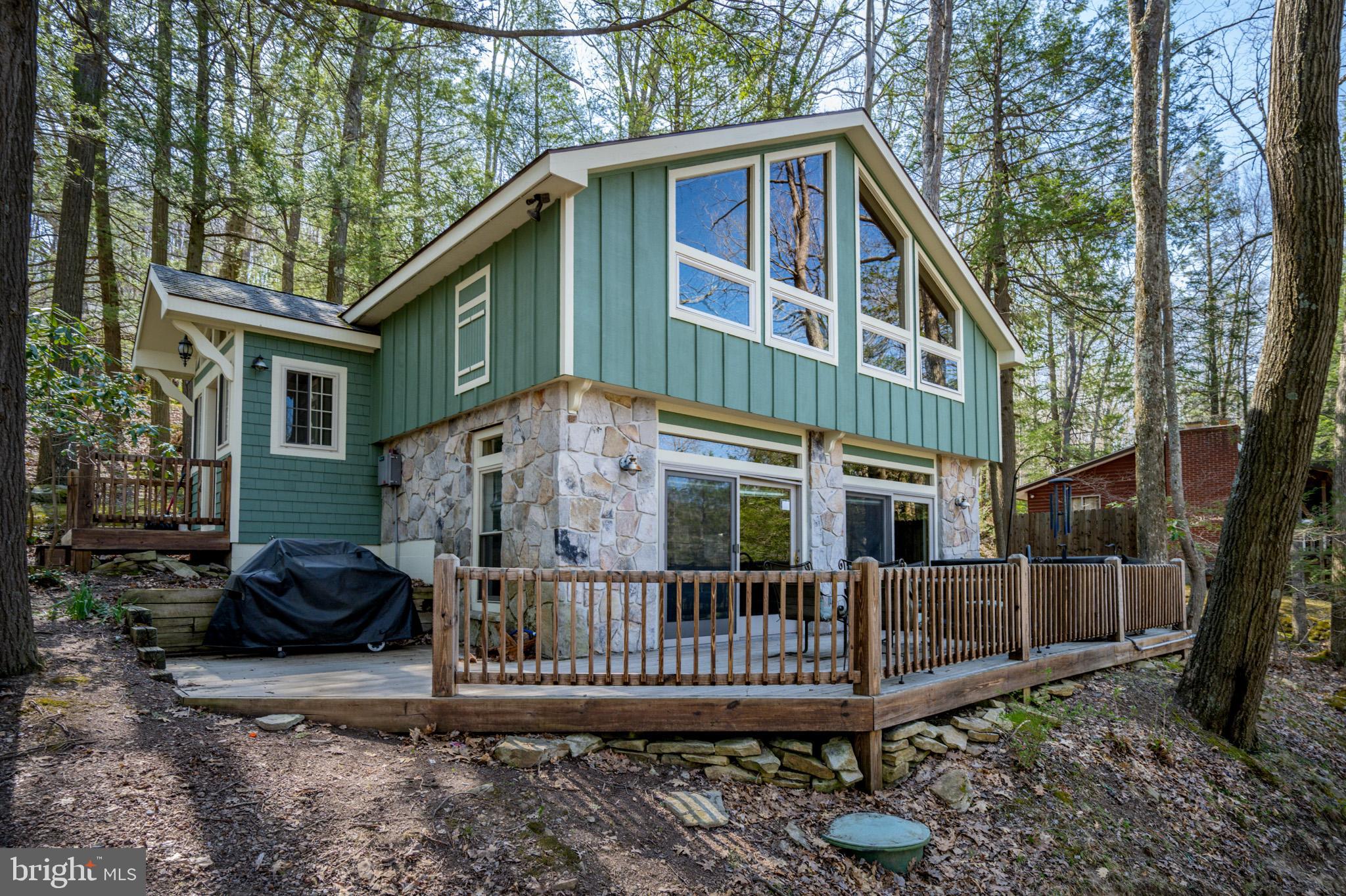 Cozy Retreat on Lake Shore Drive! This 4-bed, 3-bath cottage was built for relaxation, entertainment, and making memories. The open-concept living area keeps everyone connected, while the expansive deck and hot tub allow you to take the fun outside. Upstairs, the primary suite steals the show! A personal fireplace with a wall of glass to let in the light and soak in the views. Three more bedrooms mean plenty of space for the whole crew. An established vacation rental, "Serenity Shores" is being sold turn-key, fully furnished. Unbeatable location, just minutes from Deep Creek Lake, WISP Resort, state parks, marinas, and top dining spots. If you're looking for a charming mountain getaway with some serious Tree-House vibes, then you do not want to miss this one. Call today for details!
