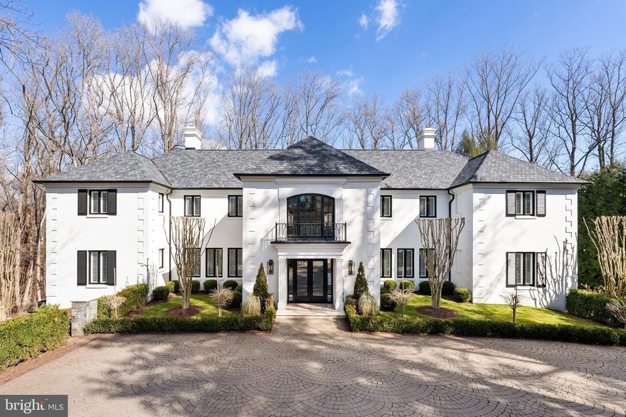 Under the careful eye of KNEAD Hospitality + Design, this stately Georgian residence has been transformed into a masterpiece of modern living, where no detail has been overlooked and no expense spared in a top-to-bottom redesign and renovation. Situated on a prime, one-acre site in one of McLean’s most exclusive enclaves, Kedleston now offers a carefree living experience with an unparalleled blend of timeless elegance, contemporary sophistication, and utter privacy.

A cloistered motor court introduces the commanding façade, where articulated quoins, an architectural shingle roof, and new stucco exterior, showcase the home’s traditional pedigree. Grand 8’ custom glass doors open to a soaring two-story foyer, setting the tone for the superbly modern interiors beyond.

The airy two-story living room with handsome stone fireplace extends onto an expansive terrace, overlooking the resort-style pool and the treed privacy of the lot beyond. The dining room, skylit family room, reimagined chef’s kitchen, and lounge offer an effortless flow indoors to out for both intimate gatherings and grand entertaining. A spacious guest suite with fireplace is an unexpected bonus. This floor is completed by two powder rooms, a beautiful walk-in pantry, and the laundry room.

The expanded chef’s kitchen has been meticulously designed for both function and appeal, seamlessly integrating with the skylit family room for an inviting, light-filled atmosphere. A premium Thermador appliance suite elevates the space, featuring a side-by-side refrigerator and freezer, beverage cooler, a six-burner range with griddle and double oven, convection/microwave wall oven, and pot filler, all complemented by Kohler fixtures. Two Neoroc sinks, a custom range hood, and seamless honed Caesarstone countertops with three-sided waterfall edges add to the refined aesthetic. A full-length Caesarstone backsplash, double islands, and a dining bar enhance both functionality and style, while quarter-sawn inset white oak cabinetry offers a timeless, sophisticated touch. For added convenience, an elevator from the garage provides effortless access to the adjacent walk-in pantry.

Upstairs, the serene primary suite is a true sanctuary, anchored by a warm fireplace and designed for the ultimate in luxury and relaxation. The spa-inspired bath boasts a glass-enclosed wet room, featuring a deep-soak Jacuzzi tub with Bask heating technology, a Kohler dual shower system with a rain shower and handheld, and radiant heated floors for year-round comfort. A separate water closet, integrated TV, and floor-to-ceiling wire-brushed marble tile add to the refined ambiance. The suite also offers two boutique-caliber walk-in closets, custom designed for both style and function. Three additional bedrooms and two full baths complete this level, each offering views of the lush, verdant landscape.

The lower level seamlessly extends into an exceptional screened loggia, complete with a fireplace, spa, and multiple lounge and entertaining areas—a true indoor-outdoor retreat. Just beyond, an expansive patio surrounds the heated pool, creating a resort-like oasis. This level is designed for both luxury and functionality, featuring a dual-sized waterfall-edged wet bar built for entertaining, a temperature-controlled wine cellar, exercise studio, and an additional guest suite. A powder room adds convenience, while a private sauna and steam room elevate the wellness experience. For added versatility, a dedicated office space can easily serve as a seventh bedroom. A private entrance provides seamless access for family or staff, leading directly to the elevator and the redesigned three-car garage.

Rarely will you find a residence of this stature, elegance, and meticulous craftsmanship. Kedleston is more than a home—it is a legacy estate. Available fully furnished for the ultimate convenience of its next owner.