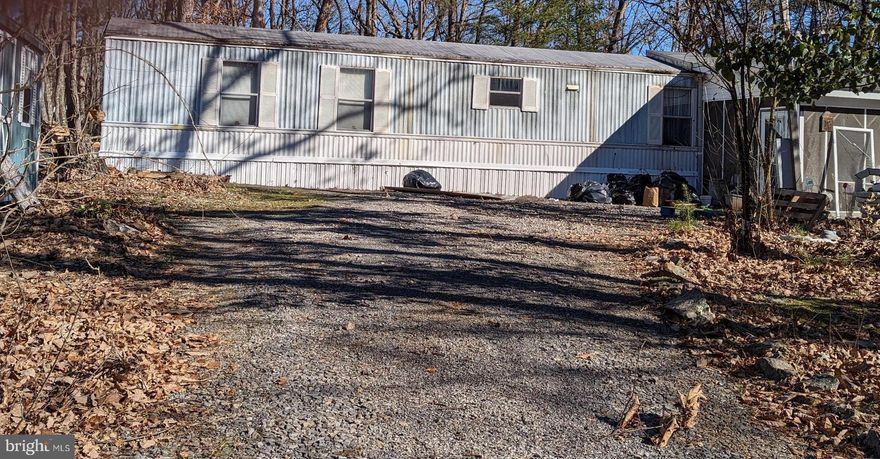 1999 mobile home on 5.06 acres, mostly wooded and very private!  Affordable investment property, permanent residence, or week-end get away.  Home offers two bedrooms and two bathrooms and is partially furnished.  You can sit out on the large screened porch and enjoy nature without the bugs!  Bring your ATV's and hunt right in your own yard.  Home is move in ready but the exterior property and porch will need some clean up and TLC.  Property is being sold as-is.