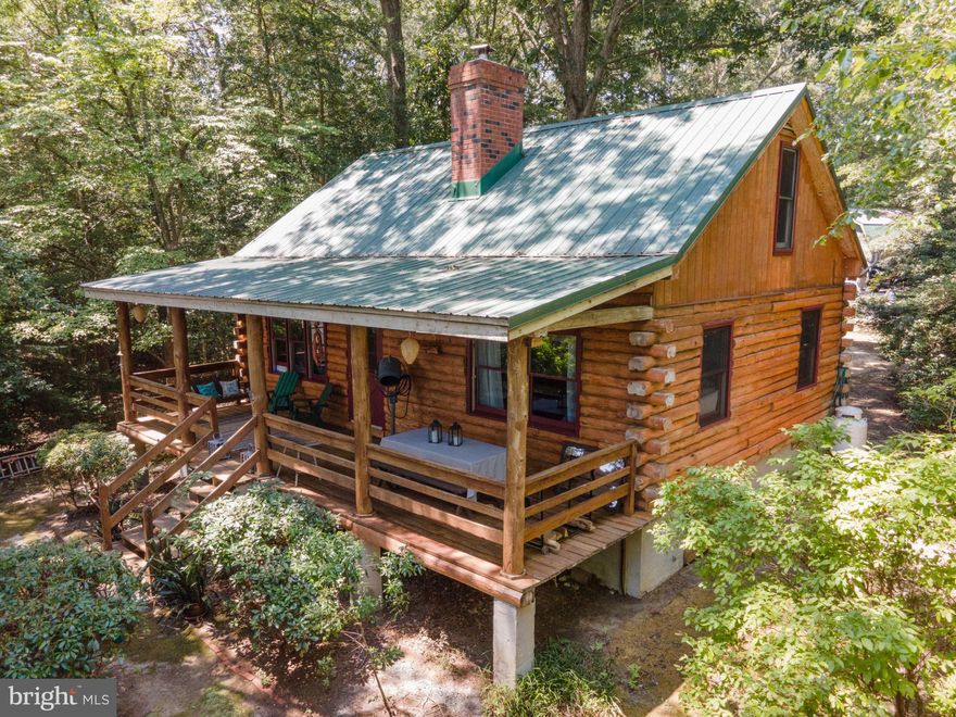 First Time Offering of this Storybook Log Cabin on over 9 acres with deep water pier on sought-after Myer Creek off the Corrotoman with easy access to the Rappahannock River & The Chesapeake Bay. This beloved custom cabin oozes charm and has 2 bedrooms, 2 full baths, an extra sleeping or office space, and a nostalgic kitchen with antique sink, pie cabinet and flour cabinet for storage.  Authentic log construction with rustic wide plank hardwood floors.  The great room & primary bedroom have amazing views of the waterfront.  A Cozy wood stove fireplace is perfect for fall or winter evenings & the huge covered waterfront porch has room for family dining & lounging on the porch swing with a good book.  There are literally endless possibilities for this special property that features 4 acres of woodlands, cleared fields, a fenced garden with water, a detached oversized garage/workshop with power & heat, & a finished "man-cave" bar upstairs that could easily be converted to conditioned living space.  This "Camp-like" setting also includes a garden shed for storage, a "she-shed" that would make a great yoga or art studio, a large pavilion with an oil changing pit - perfect for the car buff in the family/equipment storage or even a great covered party pavilion space for large gatherings or picnics. There's also a cute octagonal gazebo near the garden and a covered firewood pavilion near the cabin. With 130' of frontage on Myer Creek, a newly restored dock in progress, 3 extra-large boat slips, and  7' MLW sailboat-depth protected water (buyer to confirm water depth), bring your large boats, your kayaks, your fishing rods & your crab pots to really take advantage of the Northern Neck River Lifestyle. No HOA and whole house generator make this a unique short-term rental option as well. This convenient, private, serene setting is just minutes from the free Merry Point Ferry for a faster commute to the charming towns of Kilmarnock, Irvington and White Stone for fine dining and shopping options and across the creek from Yankee Point Marina for all your boating needs. This property has too many details to count, and you can easily imagine making it your dream getaway, family compound, primary home,  grown-up camp, writer's retreat or simply your happy place. Don't wait to see this dream Northern Neck property!