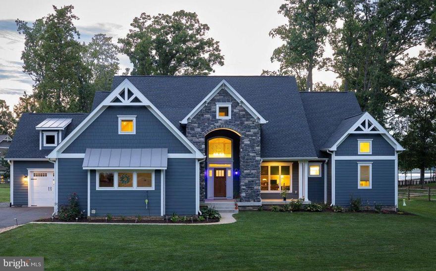 Welcome to luxury lakefront living at its finest! This stunning custom-built waterfront home by Spartan Homes is located on the private side of Lake Anna in the sought-after Noah’s Landing subdivision. Perfectly situated on a .95-acre lot with 160 feet of prime water-frontage, this property offers expansive, unobstructed views across one of the widest sections of the lake. Step inside to an elevated level of craftsmanship and comfort. The open floor plan on the main level features vaulted ceilings, rich hardwood flooring, and a striking floor-to-ceiling stone gas fireplace. The gourmet kitchen offers granite counters, stainless steel appliances, a center island with seating, walk-in pantry, and warm wood cabinetry, all open to the living and dining areas—complete with elegant coffered ceilings. The main level lakeside primary suite is a peaceful retreat with direct access to the covered patio, two walk-in closets, a luxurious soaking tub, separate tiled shower with glass enclosure, and a double vanity. An additional main level bedroom (or ideal home office), full bath, and laundry room complete the main floor. Upstairs, you’ll find two guest bedrooms, each with private ensuite bathrooms, plus a massive bonus room over the garage—perfect for a game room, bunk space, or media area—and a flex room or storage space for added versatility. Enjoy gorgeous lake views from the screened porch or entertain on the back patio. Just steps away, the deep-water boathouse includes a covered boat slip with electric lift, double jet ski pad, tiki bar, large storage room, and a spacious partially covered sun deck—ideal for sunset lounging after a fun day on the water. There's even a natural sandy beach perfect for little swimmers! Additional features include a finished 3-car attached garage, paved driveway, large workshop, lake-fed irrigation system, and bulkhead is already in place. This waterfront retreat checks all the boxes—luxury, comfort, and endless lakefront enjoyment. Don’t miss your chance to own a slice of paradise in one of the most desirable neighborhoods at Lake Anna!