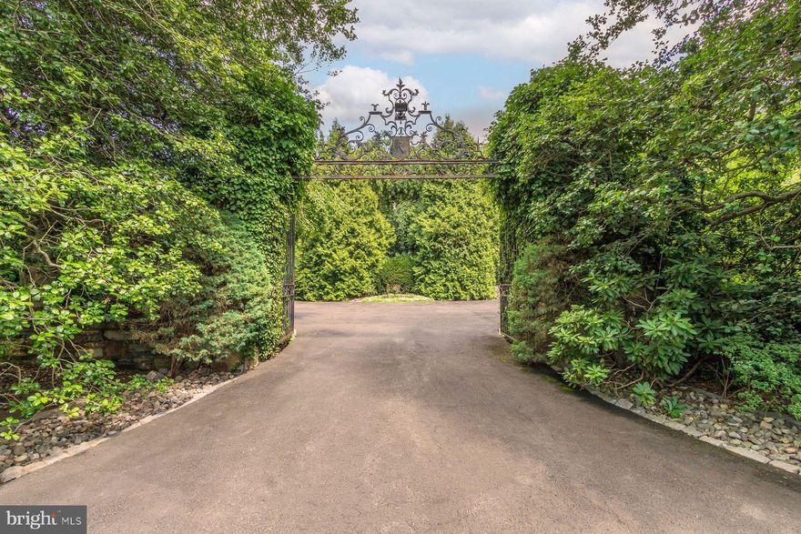 Elegant & refined Neo-classical architecture circa 1938. The setting is splendidly private on 6 + acres of breathtaking towering trees, specimen landscaping & verdant lawn. Built with pride & skill at the pinnacle of fine materials & craftsmanship! A gated entrance opens to an inner gate with its heralding detailed crest, setting the tone of this truly stunning property! A classic portico is flanked by well-planned & proportioned stone wings, towering chimneys & detailed woodwork & ornamentation creating symmetry & balance. These elements quietly contribute to the mystique of this true manor residence. Originally built for George W. Elkins founder of Abington Hospital, his family, hence Elkins Park. The current owner has been a valuable steward in carrying the torch for its next fortunate owner. Substantial planning & personal attention were considered during its construction and is reflected in the particulars of this remarkable 6-bedroom, 7 full & 3 half bath home. As you enter through an impressive doorway, the foyer presents a gracious staircase flooded by light & accented by eye catching balustrades, pilasters, raised paneling & fine woodwork. An elevator also conveniently takes you to upper & lower levels. A remarkable hall of extraordinary length leads to rooms of substantial dimensions but at the same time they offer a welcoming environment. High ceilings, extensive use of crown moldings, elegant door pediments, intricate trim and 8 finely detailed fireplaces add to its wonderful makeup! A reception room with expansive window, fireplace, travertine floor is the first to greet you. A relaxing T.V. room with fireplace, wet bar & wall of glass creates an intimate contemporary setting for unwinding. The center point of a large formal living room is the mantled fireplace flanked by French doors, built in display cases for your prized collectibles & extensive wall space for art display accented by custom lighting. An impressive curved black granite wet bar adds to the visuals. A focal point of the adjacent solarium with dramatic wraparound arched French doors is a magnificent whimsical starburst metal sculpture accented by surroundings partridges. A banquet sized dining room with fireplace & oversized windows is complemented by crown molding, raised panel wainscot & intricate door trim. The center island kitchen with honed stone floor features cherry & sleek stainless cabinetry, granite counters, stainless appliances include Wolf, oversized Sub-Zero, Asko, Profile, Aobosi. An adjacent solarium with classic black & white marble checkerboard floor is perfect for breakfast & informal dining. A separate cook’s kitchen with huge granite center island offers 6 burner Viking Professional induction stove & 2 ovens. An adjacent card room with custom built-in cabinetry finishes this level. The second floor offers a lavishly appointed primary bedroom suite with sitting room, 2 fireplaces & 2 luxurious baths. There are 4 additional en-suite bedrooms, two of which have fireplaces. An office/TV room finishes this floor. The upper level of this exceptional home is complete with a bedroom, full bath & large game room. Adding to the trappings of this captivating property are extensive flagstone, & brick patios, a wonderful heated inground pool with entertainment cabana & tennis court. The Sportsplex is astonishing! It offers a basketball & racket ball court, locker room, showers, sauna and a full galley kitchen. Both the first & second floor of this amazing faciity features separate bar & entertainment spaces + a gym area overlooking an enormous indoor heated inground pool-spa. This is one of Montgomery County’s finest estate properties waiting for your enjoyment! Minutes to Philadelphia and convenient to all major roads & transportation!