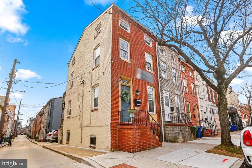 This end-of-group home in the heart of Fells Point is the definition of Baltimore charm, featuring multiple decorative fireplaces (plus one fully functional gas fireplace), exposed brick, original hardwood floors throughout, and a unique yet highly functional layout full of character. Almost unheard of in the city, this property also offers private two-car side-by-side parking in the rear, a true rarity for this location!!!

The cozy main level welcomes you with a living room centered around a fully functional fireplace that opens to an updated kitchen with stainless steel appliances, creating the perfect blend of historic charm and modern convenience. This level also features a balcony off the kitchen and direct access to the rear parking pad, ideal for everyday ease and entertaining.

The second level offers one bedroom, one full bathroom, and an additional room perfect for an office or flex space, along with access to a private balcony. The entire third level is currently used as the owner’s suite, featuring a spacious bedroom, full bathroom, walk-in closet, and another private balcony retreat.

The lower level includes a bedroom (currently used as a gym), a half bathroom, and private rear access in addition to interior access, making it a great option for guests, workspace, or additional living space.

Located just four blocks from the waterfront in Fells Point, you’ll enjoy easy access to some of the city’s best restaurants including Little Donnas and Brunch Supple , bars, and coffee shops, and only five blocks from Johns Hopkins Hospital, making this an ideal location for both work and social life within walking distance.

This home has also been meticulously updated with major improvements, including:
• New roof (2025)
• New HVAC system (2024)
• New hot water heater (2023)
• New washer & dryer (2025)
• New dishwasher (2022)
• Additional lighting, deck, security, and system upgrades throughout

Rarely available, full of character, and loaded with upgrades, this is a true Fells Point gem offering the perfect mix of historic Baltimore style and modern living.