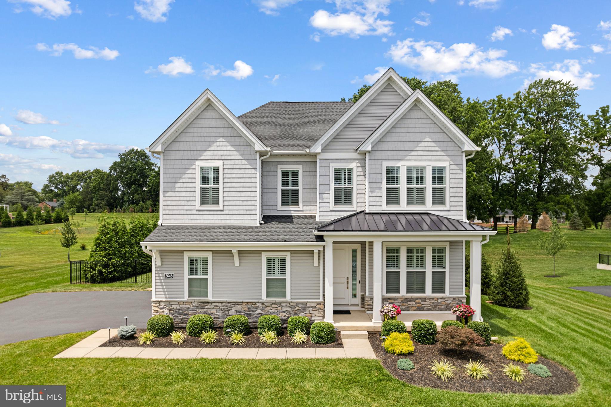 Welcome to this stunning 4-bedroom, 5 bath home in the highly sought-after Reserve at Center Square, ideally situated on one of the community’s premier private lots. Built in 2022 and thoughtfully upgraded with over $300,000 in enhancements, this home offers the perfect blend of modern design, comfort, and functionality.
Step inside to find an open and airy floor plan with engineered hardwood flooring and soaring ceilings throughout the main level. The welcoming foyer sets the tone, with a formal dining room to the right—ideal for gatherings and holidays. At the heart of the home is the gourmet eat-in kitchen, featuring soft-close cabinetry, a large quartz center island, high-end stainless steel appliances, and a sunlit breakfast area. The kitchen flows seamlessly into the spacious family room, where oversized windows flood the space with natural light, and a gas fireplace adds a cozy touch. Sliding doors lead to a beautifully finished two-tier outdoor space with a custom Trex deck, lower-level paver patio, fenced-in yard, and exterior lighting—perfect for entertaining or relaxing. Also on the main level is an office / flex space with French doors and a powder room, tucked away for function and flexibility. Rounding out this floor is a mudroom which leads to the oversized two car garage.
Upstairs, a large open space at the landing provides the perfect bonus area for a second home office or teen hangout—before branching off to the home’s four spacious bedrooms and three full bathrooms. The luxurious primary suite features a spa-like bath—complete with dual vanities, oversized glass-enclosed shower with bench, and an amazing custom walk-in closet. There is a second-floor laundry room, adding extra convenience for everyday living. Back downstairs to the fully finished, walk-out basement is another 1000 sq feet of living space, currently set up as a home gym and media room. This floor also includes a second powder room and a large unfinished storage area. Upgrades include a whole-house generator, custom closets in every room, irrigation system in the front yard, 5-foot black aluminum fencing, professional landscaping, motorized shades on both sliders, custom shutters throughout, ceiling fans and recessed lighting, and upgraded tile and countertops throughout. No detail was overlooked in this meticulously maintained home, set in a peaceful community with scenic walking trails and a tranquil lake. Located in the Methacton School district, 2468 Hawthorn Drive is close to major commuter routes, Heebner Park and the Zacharias Creek trail, Merrymead Farm, shopping and dining in Skippack Village, Blue Bell and more! This home offers a rare opportunity to enjoy refined suburban living with every modern amenity. Don’t miss it—schedule your private tour today.