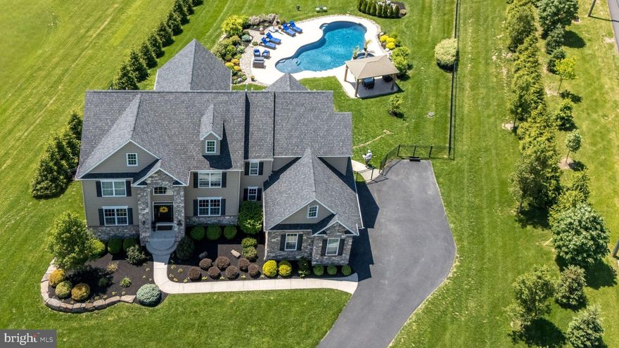 Welcome to your dream home where luxury living meets breathtaking views in the heart of Central Bucks School District. This stunning estate home is set on beautifully landscaped grounds w/ sweeping long-distance views of the rolling Bucks County countryside & is nestled on a quiet corner w/in an enclave of custom homes by Evans Bldrs. Here, you’ll enjoy the best of both worlds — a private, family-friendly setting just minutes from shopping, restaurants, & vibrant downtown Doylestown. Spend your summers living the resort lifestyle in your own backyard paradise, featuring a 30,000-gal. heated saltwater concrete pool & spa surrounded by a stamped concrete patio & charming pergola. The prof. landscaped property also incl. an irrigation system on the front & sides, privacy tree borders, black aluminum fencing, & a full exterior lighting package. The maintenance-free stone & siding exterior adds even more curb appeal. Step inside & be immediately impressed by the gorgeous grand staircase w/ wrought iron balusters & bright, open floorplan designed for today’s lifestyle. Freshly painted in a trendy neutral palette, the home flows beautifully w/ 5-in. stained oak hardwood flooring running t/o the entire 1st floor & 2nd floor hallway. The grand foyer opens to a center hall flanked by formal living & dining rooms, each w/ elegant tray ceilings & custom millwork. For those who work from home, a 1st floor office w/ scenic backyard views offers the perfect spot for productivity. At the heart of the home lies a spectacular chef’s kitchen. Custom dark cabinetry w/ custom inserts, granite countertops, 14-ft. center island, separate built-in refrigerator & freezer, wine fridge, double wall oven, 5-burner gas cooktop, microwave drawer, & a spacious walk-in pantry make this kitchen a showstopper. Plus, just off the dining room, you’ll find a butler’s pantry (2nd kitchen!) w/ an add'l beverage fridge, dishwasher, & sink for effortless entertaining. The kitchen flows seamlessly into a two-story family room featuring a soaring 16-ft. coffered ceiling, gas fireplace, & walls of windows framing the lush backyard. Nearby, a custom mudroom w/ a built-in bench, bead-board, cabinets, & cubbies connects you to the oversized 3-car garage & a 20’x20’ Trex deck — complete w/ vinyl railings & stairs down to the backyard oasis. Two powder rooms & abundant closet space round out the main level. Upstairs, you’ll find 9-ft. ceilings & an airy, open hallway w/ a cozy sitting area & balcony overlooking the family room. The grand primary suite is a true retreat, complete w/ a private sitting room/dressing area, multiple closets, & luxurious ensuite bath featuring a freestanding soaking tub, two marble vanities, an impressive walk-in shower, upgraded tile-work, & a private water closet. A princess suite w/ its own private bath & two add’l bedrooms connected by a Jack-and-Jill bath provide plenty of space for family or guests. The 2nd floor laundry rm w/ folding counter & new washer & dryer adds everyday convenience. The 1st & 2nd levels alone offer a whopping 4,421 sq. ft. of living space. The possibilities continue with a FULL, WALK-UP 3rd FLOOR already equipped w/ windows & electric — ready for your finishing touches to create up to an add’l 2,000 sq. ft. of living space! The finished walk-out basement offers another 1,400+ sq. ft. of flexible living, complete w/ large TV area, private bedroom, full bath, potential media/exercise room, & multiple storage spaces. Add’l updates and features include: New carpeting in all upstairs bedrooms (May 2025), New dishwasher (2024), Basement waterproofing, Water softener, Radon mitigation system, Custom window treatments, Two-zone HVAC (1 AC unit replaced 2023), 440-amp Electric service, Newer well pump w/ safeguard alert (2022), & pool system’s Salt cell & Coil replaced (2023). This home truly offers the perfect blend of elegance, functionality,  outdoor living - there’s simply too much to list!