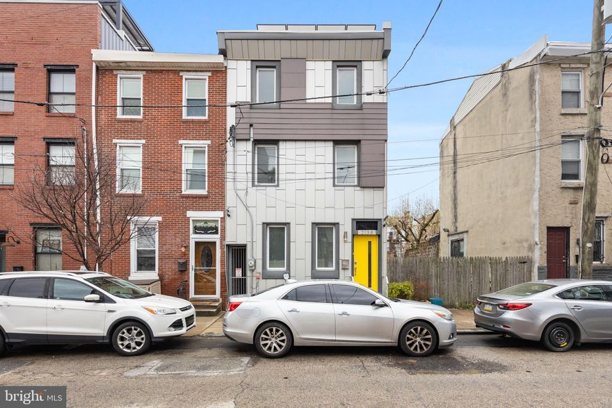 Here's your chance to own a unique property that puts you in the middle of all Fishtown has to offer, including restaurants, coffee shops, boutiques, and bars! 2138 E Arizona St. welcomes you with high ceilings and hardwood floors.  On the main floor, you'll find a comfortable living room, charming breakfast nook with a custom bench, and a convenient powder room.  With its abundance of natural light, premium cut granite countertops, oversized island, and stainless steel appliances, the stylish kitchen is sure to impress.  It leads to a spacious backyard with a fully paved surface. It is the perfect place to host family and friends.  When not entertaining, there is parking for two cars as well as an EV charging port that is hardwired all secured by a rolling garage door.  On the second level, there are two large rooms and a modern ceramic tiled bathroom. After a long day, the private primary suite on the 3rd floor offers a luxury en-suite bathroom with a fully tiled walk-in shower and a double sink vanity.  From the primary bedroom, you can enjoy the view from the roof deck. Additional flex space is available in the partial basement.  Additionally, you can enjoy the savings of solar panels without paying an additional monthly fee. Make sure you schedule a tour before it's too late!