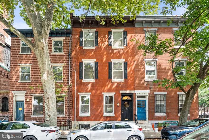 Welcome to 707 Catharine Street: a timeless gem nestled on a picturesque tree-lined street in Bella Vista. This 18' wide, 3,000+ square foot home invites you to experience a lifestyle steeped in warmth and character.
A beautiful, traditional brick façade, decorative cornice, and original black Tofani door welcome you to create a lasting first impression. Step through the vestibule, adorned with a stunning stained glass transom window, and be greeted by gleaming hardwood floors that reflect the natural light pouring through expansive windows. The grand living room, with its soaring 10.5-foot ceilings and intricate crown molding, is the perfect backdrop for gatherings and cozy evenings. A recently added half bath adds a touch of modern convenience to this classic space.
Transition effortlessly into the dining room, where wainscoting and a built-in coat closet enhance the charm. The heart of the home is the fully renovated kitchen—a culinary dream featuring rich wood cabinets, luxurious quartz countertops, and an apron sink. The inviting peninsula offers ample seating, making it ideal for both casual breakfasts and lively dinner parties.
 Step outside to the large tiled patio, your personal backyard oasis, complete with built-in planters, paw paw trees, and vibrant tulips that bloom each spring—perfect for grilling, entertaining. 
Ascend the original wood staircase to discover the second floor, where a serene primary suite awaits, complete with a spacious bedroom and an ensuite bathroom. A hallway bathroom with a shower and a second bedroom with an extra room provide versatility for family or guests. The third floor unveils another primary bedroom, a full hallway bath featuring a luxurious jacuzzi tub, and an additional bedroom with an office/study attached. The fully finished lower level is a versatile space, perfect for a den, playroom, or home office. It also includes a laundry/storage room and a convenient half bath. 

Located in the vibrant Bella Vista neighborhood this home comes with an added benefit of being in the Meredith Catchment. It is also just steps away from local favorites like John's Water Ice, Fleisher Art Memorial, Palumbo Park, Saloon, and Fitzwater Café. Plus, you're only a short stroll from the bustling Queen Village,  the iconic Italian Market, and Passyunk Square: offering endless opportunities for dining, shopping, and community. Experience the charm and lifestyle of 707 Catharine Street—your dream home awaits! ***Offering 1% INTEREST RATE BUYDOWN for the 1st year at ZERO cost to the homebuyer when using our preferred lender.***