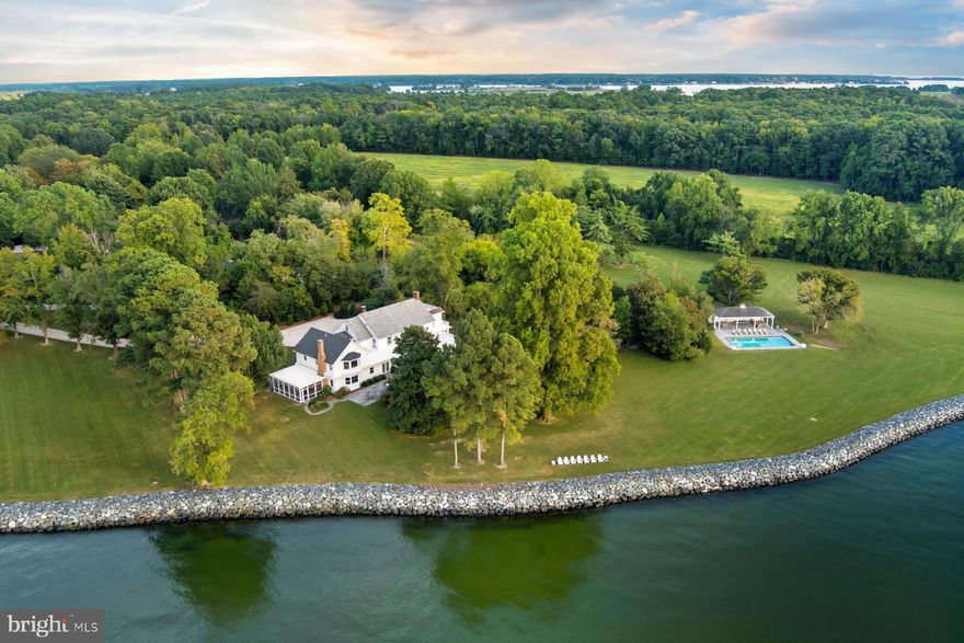 "Bolton Farm", available for the first time in over two decades, is an exceptional offering of rare privacy, including a renovated manner house, historic guest house, new four stall horse barn, pool and tennis.  Originally known as Quaker Kemp Farm, dating back to 1790, this remarkable 115-acre waterfront estate with two deeded lots has breathtaking western views across the Chesapeake Bay. A gated entrance and mature tree-lined drive create a gracious approach to the main residence while highlighting the property’s stunning water views, natural beauty with mature landscaping and specimen trees. 

The generous porch front manor house blends classic architecture with relaxed coastal style with newly updated kitchen and baths.  The expansive waterside living room features brick flooring and floor-to-ceiling windows and French doors that flood the space with natural light and showcase stunning water views. A formal living room and dining room sit adjacent, seamlessly connecting the rooms.   The well-appointed kitchen and family rooms include a large center island, breakfast area, wet bar, high-end stainless appliances, built-ins and fireplace. A waterside screened porch extends the living space outdoors, perfect for dining and relaxation. The main floor also offers a guest or owners suite with an en-suite marble bath. The paneled mudroom and powder room complete this floor. 

Upstairs, the hall landing provides access to the generous primary suite which includes built-ins and a beautifully appointed en-suite marble bath. Two additional bedrooms are connected by a renovated bath.  The oversized fourth bedroom suite includes a sitting room, en-suite bath and stunning views.  This floor is completed with a laundry room.  The third floor provides two additional guest bedrooms and a shared full bath.  The lower-level basement offers excellent storage.  

The charming brick guest house, circa, 1790 has two-bedrooms featuring a new cedar shake roof, center hall, high ceilings, wood floors, moldings, full kitchen and renovated bath.  
 

The Equestrian and agricultural amenities include a new four-stall barn with loft game room, fenced pastures, a wooded forest, two equipment barns, and a greenhouse/garden shed. Meandering paths connect the main house, guest house, and barns. The property includes a parcel across from the main entrance to ensure additional privacy.  

The outdoor features give the farm the opportunity for large family occasions with numerous areas to gather and enjoy the stunning sunsets.  Features include a waterside pool, covered pavilion, private tennis court, two ponds, a pier and hiking trails throughout the expansive grounds.  
 
An adjacent 37+-acre waterfront parcel (included in the total acreage) has a sandy beach and offers additional opportunity, with approvals in place for a seven-bedroom main residence and a three-bedroom guest house. 
 
With nearly 4,000 feet of riprapped shoreline, “Bolton Farm” represents a rare offering on Maryland’s Eastern Shore.