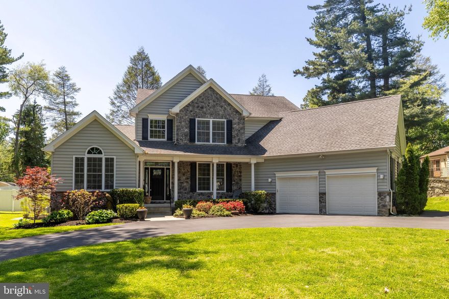 Welcome to this beautifully maintained custom-built residence located at 1086 Kingsley Rd in the desirable Crosswicks neighborhood of Rydal, PA in Abington Township. Built in 2015 and set on just over .5 acres, this property offers timeless curb appeal, thoughtful upgrades, and inviting living spaces inside and out. A horseshoe paved driveway, manicured landscaping, mature trees, and an attractive stone-and-siding exterior create a lasting first impression. Step inside to a bright, open layout where the entire main level features rich hardwood flooring, soaring ceilings, large windows, and abundant natural light. The dramatic two-story living room showcases an impressive wall of windows, a cozy gas fireplace, and a seamless connection to the kitchen, making it ideal for everyday living and entertaining. A graceful staircase with rich wood accents, classic white spindles, and an open loft above adds architectural elegance while enhancing the spacious, airy feel. The kitchen is both elegant and highly functional, featuring cream cabinetry with detailed trim, granite countertops, tile backsplash, stainless steel appliances, 5-burner gas cooktop, lower oven with built-in microwave above, expansive center island with seating, illuminated glass-front display cabinets, generous storage, beverage area with sink and wine storage, and walk-in pantry. The adjoining formal dining room offers crown molding, chair rail detail, and a large window overlooking the front yard. A dedicated office with vaulted ceiling and arched window creates a comfortable workspace. The first-floor primary suite offers a private retreat with hardwood flooring, crown molding, recessed lighting, ceiling fan, large windows, and an en-suite bath with heated floors, granite-topped vanities, and a spacious tiled walk-in shower with glass enclosure, built-in niche, bench seating, rain-style shower head, and body sprays. Main-level laundry with cabinet storage, utility sink, and direct exterior access adds everyday convenience. The upper level includes three additional bedrooms with generous natural light, ceiling fans, recessed lighting, ample closet space, and neutral finishes. A well-appointed hall bath includes a double-sink granite vanity and tiled tub/shower. The open loft overlooks the two-story living room, creating flexible space for a sitting area, study zone, reading nook, or second office. The finished lower level expands the usable square footage with a recreation/game room, media area, exercise space, luxury vinyl plank flooring, recessed lighting, convenient half bath, and room for hobbies, fitness, or play. A large walkout staircase brings natural light into the basement while providing exterior access to the yard. Additional highlights include abundant dimmable recessed lighting, interior nighttime pathway lighting, underground electric service for a clean exterior appearance, and a whole house generator for dependable backup power and peace of mind. Outdoor living is a true highlight, with just over .5 acres of beautifully maintained grounds, a covered rear patio with stone accents, ceiling fan, recessed lighting, gas fireplace, and mounted TV area, plus an expansive paver patio for dining, lounging, grilling, and entertaining. The large, level, fenced backyard is surrounded by mature trees and privacy fencing, offering usable green space to relax, play, garden, or gather. Located in the Abington School District (McKinley Elementary), the area offers close proximity to Jenkintown, local shops, restaurants, cafes, parks, and everyday conveniences. Commuters will appreciate access to the Jenkintown-Wyncote Train Station and multiple nearby regional rail stations. Nearby highlights include Abington Art Center, Alverthorpe Park, and Crosswicks Bird Sanctuary, a 14+ acre natural area within walking distance of the property. This custom-built Crosswicks residence offers the space, upgrades, location, and outdoor setting you’re looking for.