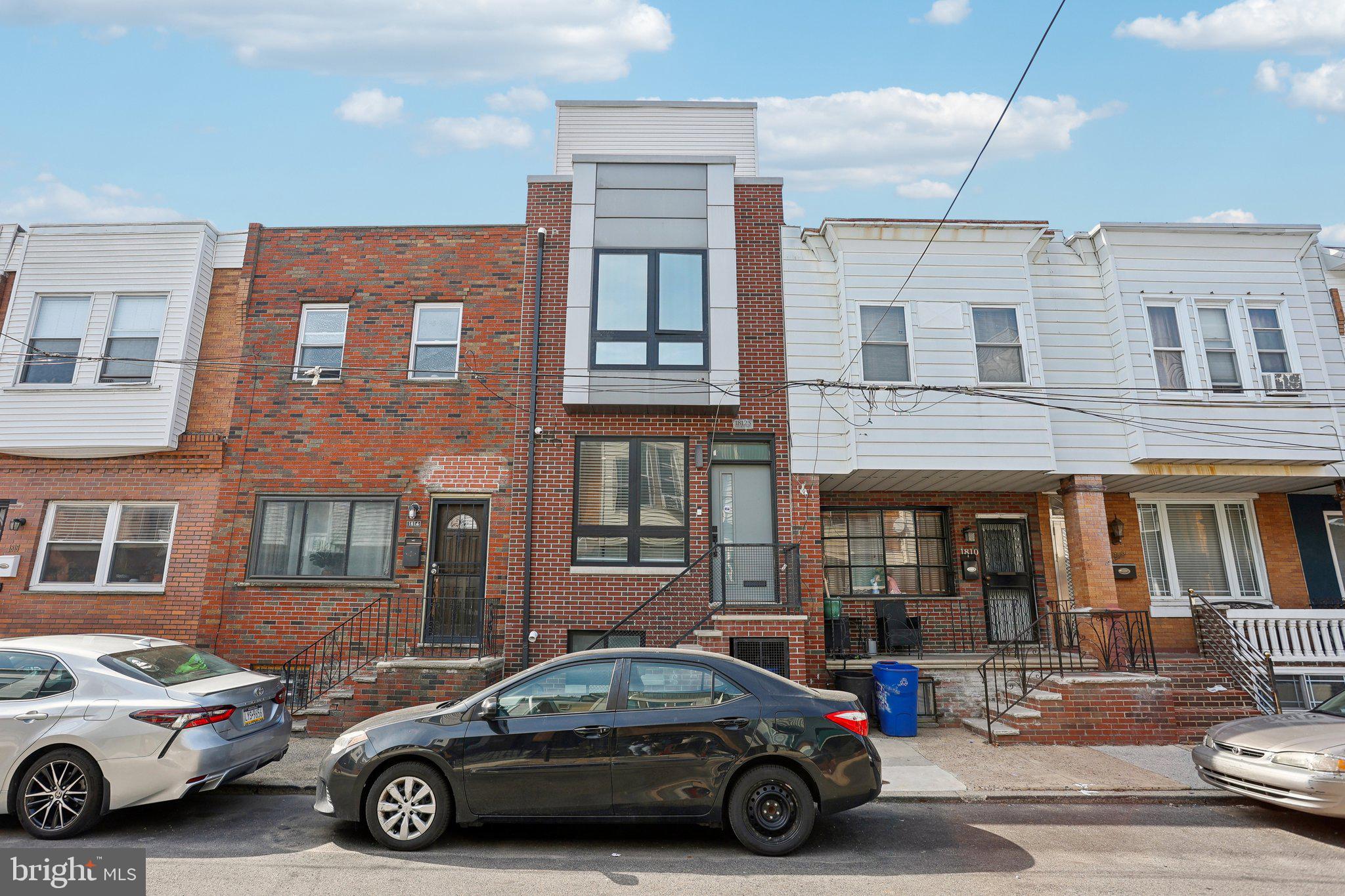 Welcome to this stunning rowhome built in 2022 in the highly desirable Point Breeze neighborhood, offering 7 years remaining on the tax abatement. Upon entering, you’ll be greeted by a bright, open-concept main level with gleaming light wood vinyl flooring that flows seamlessly from the spacious living room into the dining area and through to the gorgeous eat-in kitchen. This chef’s dream features ample, unique natural wood cabinetry, sleek Quartz countertops, top-of-the-line stainless steel appliances, a pantry, and a breakfast bar perfect for casual dining. Sliding glass doors lead out to a private back patio, perfect for enjoying your morning coffee or entertaining. The second level boasts two generously sized bedrooms, each with large closets, and a shared full hall bathroom complete with a tub/shower combo. The entire third floor is dedicated to the luxurious primary suite, featuring a spacious bedroom with a remote-controlled ceiling fan and lighting, dual climate control, and a massive walk-in closet with custom built-ins. The ensuite bathroom is a true retreat, offering geometric tiled flooring, a dual vanity, and a glass-enclosed walk-in shower. Off the primary suite is a private balcony offering an ideal space for outdoor relaxation. This level also provides access to a rooftop terrace with breathtaking 360-degree views, including the iconic Philadelphia skyline. The fully finished basement adds even more living space with a recreation room, another full hall bathroom with a stall shower, and an additional spacious bedroom. This home also comes equipped with a wired home security system, including front and rear cameras, and an alarm dial pad for peace of mind. Located just minutes from I-95, I-76, and the vibrant, up-and-coming Bellwether District, this home offers both luxury and convenience in a prime location.
