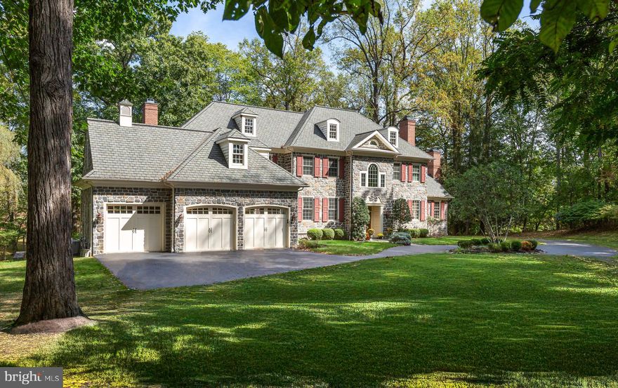 Welcome to 62 Barr, an impressive stone manor home set on 3.2 picturesque acres in the Radnor Hunt neighborhood of Willistown! Custom-built by esteemed Main Line builder E. B. Mahoney, this stately four-bedroom, three-and-a-half-bathroom home was constructed to last and has been meticulously maintained by its original owners. The breathtaking exterior boasts a stone façade, brick chimneys, and an expansive fieldstone terrace featuring custom iron railings where you can enjoy your park-like setting. Located in idyllic Willistown Township among Radnor Hunt, White Manor, Applebrook, and Waynesborough Country Clubs, this location perfectly balances the tranquility of Chester County and the accessibility of the Main Line.

This custom-built stone home is set on a private three-acre wooded lot surrounded by nature.  The charm of this home is found in the front-to-back design; its spacious entry hall leads to French doors that open to the fieldstone terrace. The nine-foot ceilings, elegant millwork, arched entryways, and gleaming Brazilian cherry hardwood floors invoke a timelessness. The living and dining rooms are the ideal spaces for entertaining guests: perfect for everything from formal hosting to everyday enjoyment. Continue into the kitchen, which boasts ample custom cabinetry, a large center island, and a restaurant-style Wolf range with six burners: truly a home chef’s dream! The breakfast room and family room both enjoy plenty of sunlight and tranquil views thanks to their proximity to the rear terrace. The family room features a hearth-to-ceiling stone fireplace, built-in shelves, a beamed ceiling, and access to a quaint, covered porch, perfect for taking in the view. From here, head into the study, with a fireplace and wood accents throughout, creating a warm ambiance. For health and relaxation, French doors off the foyer lead to a light-filled garden room with heated floors and an exercise pool.

The large three-car garage, accessed through the mudroom, includes a bonus half bath and utility sink. The laundry room is conveniently located in the hall by the back stairs that lead to the second floor. A closet space located in the hall was included to house an elevator in the future.
On the second floor, you will find the primary suite. As you enter through the sitting area, you will immediately notice the beautiful arched window with a view of the private wooded setting. This serene retreat includes a spacious bedroom with a high ceiling and French doors leading to a Juliet balcony. The suite includes two walk-in closets, a large spa-like bathroom with a steam shower, and a soaking tub. A perfect family home, you’ll find three additional bedrooms and two additional bathrooms along the classic arched hall of the second floor. An unfinished space above the garage could become a studio, au pair space, homework, or craft room. The end of the hall has a staircase to the first level and walk-up access to a floored attic for storage. Finally, the lower level has a partially finished walkout basement.  Double doors lead to the side yard and provide natural light and an egress; there’s more than enough space for additional rooms here as well to create an art studio, home gym, bar area, or fifth bedroom.
 
The true gem of this home is its setting in the highly-sought after Radnor Hunt neighborhood of Willistown Township: natural, tranquil, and private, while still convenient to the bustling town of Malvern as well as the rest of the Main Line. Enjoy access to award-winning Great Valley school district and convenient commuter options, including the Malvern and Paoli train station, with direct access to Center City Philadelphia via the Regional Rail and New York City via Amtrak. You’re never far from green space, with plenty of parks and open space in Willistown Township, as well as unbeatable access to several distinguished country clubs, including White Manor, Applebrook, Waynesborough, and, of course, Radnor Hunt Club.