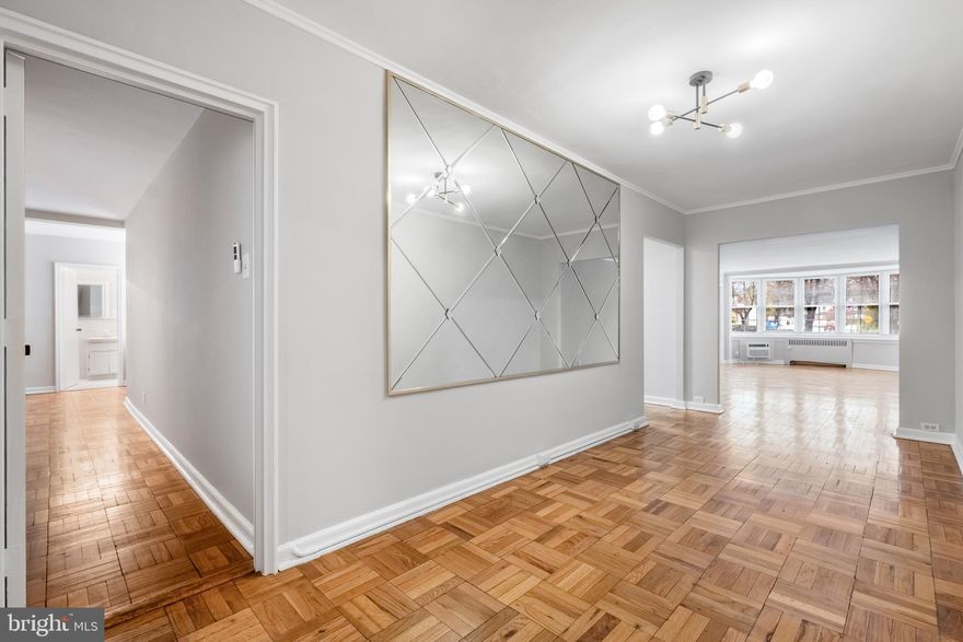 Awesome Location and Great Value all in the Lower Merion School District ! Wynnewood Plaza  2-bedroom, 2 bath large first floor condo (1414 sq ft).  Enter the foyer to find a convenient coat closet and a glimpse at this one story home. The room opens up into a space that could serve as an area for the upright piano with seating, right before the spacious living room with a large bay window to let lots of natural light in. This middle section could also be furnished as a dining room.  The galley kitchen is compact but efficient with freshly painted cabinets, new countertops, ceramic tiles backsplash and updated lighting. The adjacent dining room is generously sized with a big window.  One could also have doors installed to convert into a third room to be used as a bedroom or private home office. Down the hallway, you will find a Primary Suite with a walk in closet and en suite bathroom which has a stall shower. In addition, a second hallway bath and a 2nd bedroom with a wall to wall closet . The hall bathroom has a tub and the stacked washer and dryer are in the closet. All of the rooms have brand new wall units for air conditioning and the bedrooms have ceiling fans.  Every room is nicely sized making it feel like a house but with the convenience of a secured condo. In the lower level of the building are the storage areas for each condo, fitness room and a social/meeting room with library and entertainment kitchen. There is a shared roof deck as well for a bit of fresh air.  This extremely convenient location is .3 of a mile to Wynnewood train station and directly across from Whole Foods, steps from the Wynnewood Shopping Center across from the train station with great restaurants and stores. To get to Narberth and its shops and parks, just walk under the train overpass. Take a short walk to Ardmore restaurants and shops or to Suburban Square for the farmer's market and upscale shops.  This building is situated close to medical buildings and hospitals. The condo fee includes everything except for electric, phone and cable. There is free parking in the front and sides plus, a parking garage under the building, rental spots ($60) based on availability. The move in fee is $250, the capital contribution is currently two months of condo fees.  Industrial washer and dryer in the lower level for larger loads. The building is not pet friendly.