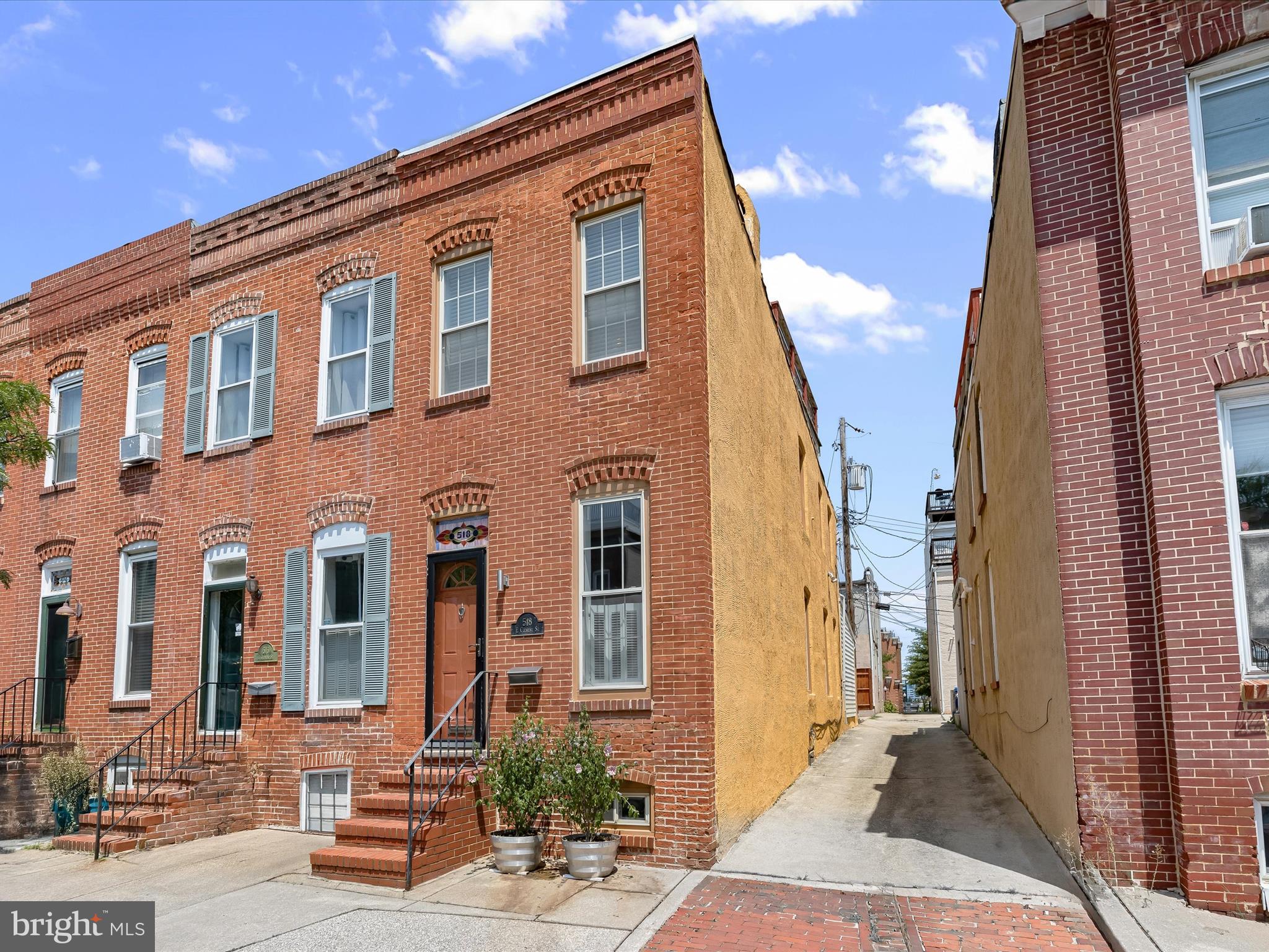 Located in the vibrant Federal Hill neighborhood, this two bedroom, two bathroom end-of-group rowhome blends historic charm with modern upgrades, complete with a parking pad and rooftop deck offering sweeping skyline views. South-facing windows fill the interior with natural light, complementing freshly painted walls in a soft, neutral tone and warm hardwood floors made of Southern Pine and Oak. The main level offers an open layout with thoughtful details like crown molding, plantation shutters, and a brick accent wall with gallery lighting that carries through the living and dining spaces. A well-appointed kitchen features new stainless steel appliances, including a gas range. A bonus room off the kitchen includes a sleeping loft, combo washer-dryer machine, and access to the oversized parking pad. A renovated full bathroom on this level adds convenience, highlighting a walk-in shower and porcelain tile. Upstairs, the primary bedroom has a vaulted ceiling, and the second bathroom is outfitted with marble tile, updated fixtures, and a tub shower. A second bedroom provides direct access to the expansive rooftop deck that is ideal for hosting gatherings or simply enjoying the panoramic views of the Inner Harbor, Domino Sugar sign, and more. Downstairs, the lower level basement has ample storage space. Additional highlights include central HVAC, a newly installed sewer lateral from the foundation to the city main, an automatic watering system for the front plants, DryLoc-sealed basement walls with freshly painted floor and steps, and exterior paint refreshed just two years ago. Enjoy the best of city living with nearby Federal Hill and Riverside Parks, sports fields, and the Inner Harbor waterfront and promenade around the corner. Minutes to Cross Street Market, Harris Teeter, M&T Bank Stadium, Oriole Park at Camden Yards and a variety of restaurants, shops, and entertainment options. Convenient access to the Light Rail, MARC Train, and I-95 makes commuting a breeze. Some images have been virtually staged.