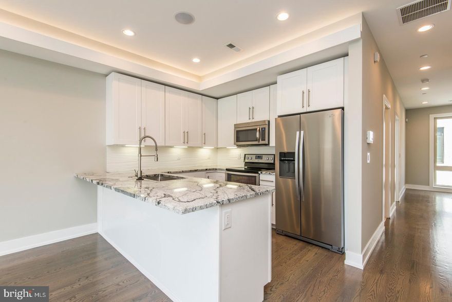 A gorgeous, newer construction unit that's ready and waiting to be called home! Enter this fantastic unit and discover the hardwood flooring, recessed lighting, high coffered ceilings with installed speakers, and large energy efficient windows which provide ample natural light. The spacious, open living and dining space offers plenty of room for entertaining friends and family, and showcases the gorgeous kitchen, which includes granite counters, stainless steel appliances, and a beautifully tiled backsplash. Continue past the kitchen to find the beautifully tiled bathroom with tub and shower combo with dual showerheads. The floor also includes a sun drenched bedroom with a walk in closet and access to a large fiberglass deck- just the spot for lounging on those sunny days! Upstairs find two more bedrooms and bathrooms, laundry, and a beautiful roofdeck with amazing views of Center City. And the location can't be beat - close to shops, restaurants, and walking distance to Center City. Don't wait, see this unit today!