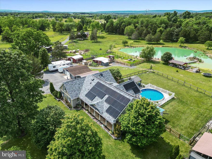 Welcome to a rare and exceptional offering in the heart of Summit Point—this extraordinary 34+ acre farm is the complete package! Whether you're seeking a private homestead, a hobby farm, or a multi-functional retreat, this property is truly one-of-a-kind.
The spacious ranch-style home spans over 4,000 sq ft and features vaulted ceilings with exposed beams, a charming country kitchen, and a bright sunroom complete with a hot tub and pellet stove for year-round enjoyment. The inviting front porch offers the perfect spot to relax and take in sweeping views of your land. Inside, the flexible layout offers three official bedrooms, plus a finished bonus room with a half bath upstairs, and two additional rooms in the basement that are ideal for guests, offices, or creative spaces. The walk-up basement also includes a large rec room, a bar area, a full bath, and generous storage areas.
Step outside into a fully fenced rural paradise designed for both comfort and function. With over 15 well-placed outbuildings—nearly all powered with electricity—you'll find two barns suited for small animals, run-in sheds, a greenhouse, feed and equipment storage, a structure for dogs , a pavilion perfect for entertaining, a chicken coop, tractor and boat storage, and even a private gun range. All structures are thoughtfully positioned within 75 feet of water access, and the property includes multiple hydrants and two automatic waterers. A stocked pond adds to the beauty and utility of this unique landscape.
Enjoy evenings by the above-ground pool, fully fenced and surrounded by durable Trex decking. Gardeners will appreciate the greenhouse, garden beds, and mature fruit plantings—including peach, pear, and plum trees, blueberry bushes, and trellised thornless blackberries.
Practical upgrades include leased solar panels that keep electric bills to a minimum (typically $6 - $12 per month), a newer HVAC system with a transferable warranty, a 2.5-year-old roof, a recently updated water heater, a whole-house water filtration and softening system, and high-speed Frontier fiber internet.
Don’t miss this rare opportunity to own a truly special property, where space, function, and lifestyle all come together in one remarkable setting. Come experience the peaceful charm and endless possibilities this Summit Point gem has to offer!