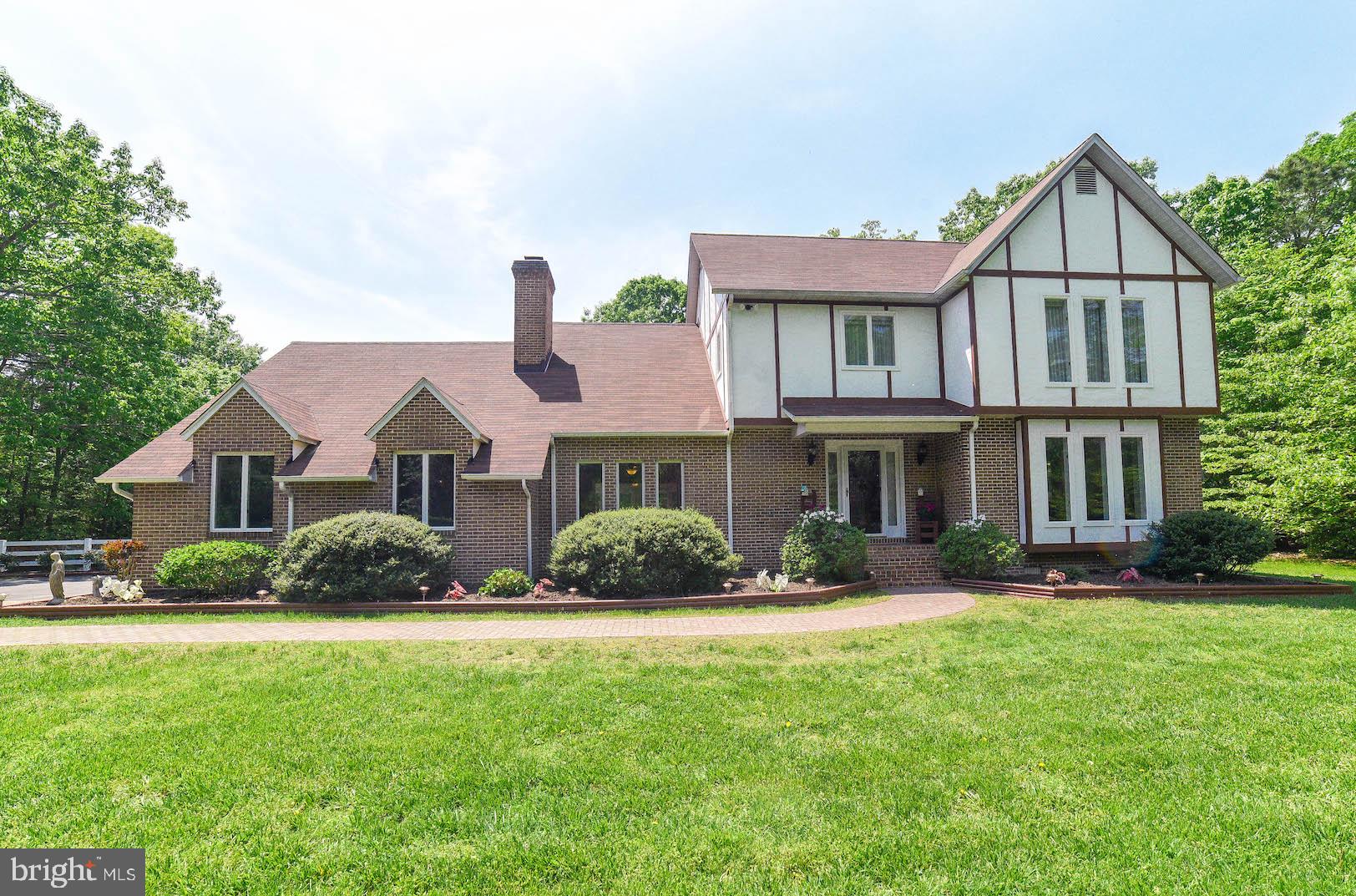 Gorgeous Tudor-style home with water rights and privileges to a private community deep water pier with slips on the St Mary's River! Situated on 5 acres, this home is nicely landscaped and offers wooded views for great privacy! Featuring a private community pier just blocks away and shared by only 12 homeowners, you'll love the lifestyle in this highly desirable area. This lovely home offers a 2-story foyer with stunning slate floors, 4 bedrooms, 2.5 full baths and a 2-car garage. Gorgeous custom paved walkway leading to the front door welcomes you! Offering a separate formal dining room that's great for family meals and special holiday gatherings! Spacious living room with with cozy carpet and lots of light that's just right for entertaining special guests! Huge family room with a gas insert fireplace with GORGEOUS brick surround - perfect for family time! An additional room on the main level with wood floors can be used as an office, play space or an extra sitting room. Simply relax in the bright sun room with lots of windows and catch the sunny breathtaking views! You'll enjoy cooking and preparing meals in the chef's kitchen boasting granite counter tops with matching back splash, center island with cook top, stainless appliances, side-by-side refrigerator, gorgeous cabinetry and ceramic floors! Off from the kitchen, relax and enjoy more wooded views from the lovely screened-in porch, featuring a BBQ grill with an exhaust system. Main level powder room plus a laundry/mud room with a wash tub for all your laundry and utility and needs! Upper level features a nice master bedroom with an attached bath, TWO closets, ceiling fan, and nice bright windows! Roomy master bath with his & her vanities! Additional bedrooms with great closet space and bright windows for natural lighting. Centrally located is the hall/guest full bathroom. Upgrades and added features include a recent replacement of the entire roof shingles (2016), fenced yard, deck area with a hot tub, a 30' above ground salt-water pool, and a back up generator to come in handy just when you need it! Energy efficient Geothermal heating and cooling! Enjoy sitting around the fire pit area for lots of fun all year round! A large shed great for storing beach chairs, boat gear, bikes, lawn equipment, tools, gadgets and more! Offering private community water privileges and more...it's time to soar and and enjoy the lifestyle that this charming home has to offer! Welcome home!
