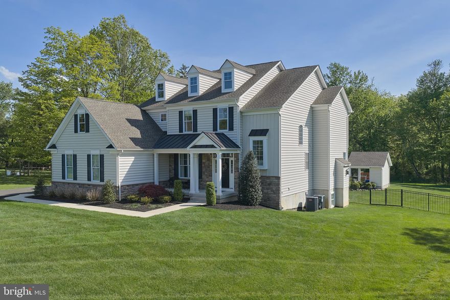 Welcome to this beautifully maintained 6 bedroom, 5.1 bath Colonial ideally situated just one mile from the heart of Newtown and within the award-winning Council Rock School District. This exceptional custom home offers refined luxury, thoughtful design, and impressive attention to detail throughout.
A grand foyer welcomes you with gleaming hardwood floors and an elegant turned staircase that sets the tone for the home’s sophisticated interior. The formal dining room is filled with natural light and accented with classic wainscoting, while the spacious family room features a gas fireplace and coiffered ceiling, flowing seamlessly into the gourmet eat-in kitchen. The stunning kitchen is truly the heart of the home, showcasing an oversized center island with seating, quartz countertops, premium stainless steel appliances, and an abundance of cabinetry. A wall of windows fills the space with natural light while offering peaceful views of the private, tree-lined backyard and pool. Sliding glass doors lead to a composite deck and custom paver patio, creating the perfect setting for outdoor entertaining. The first floor also offers a private first-floor study with vaulted ceiling and is tucked away from the high traffic area of the house that is perfect for zoom meetings and important business  calls. In addition , there is a first floor Guest Bedroom and Bath. A spacious laundry room and powder room complete the main level. Upstairs, the expansive primary suite offers a dual-entry walk-in closet, tray ceiling  and a luxurious ensuite bath with double vanities, a soaking tub, and a large walk-in shower. Three additional generously sized bedrooms with ample closet space and 2 full baths complete the second floor. The fully finished walk-out basement provides exceptional additional living space, including a media/lounge area, game space, workout area, and a bedroom ideal for guests or extended family. Outdoor living is equally impressive with a spacious fenced backyard, beautiful in-ground pool and spa, cabana, separate lounging area, and lush landscaping designed for both relaxation and entertaining. Additional highlights include owned solar panels, a storage shed, 2 UV Tesla chargers and a 3-car side-entry garage. This move-in ready home offers the perfect blend of elegance, comfort, and convenience, just minutes from downtown Newtown’s shopping, dining, and entertainment. Don’t miss this exceptional opportunity in the heart of Newtown!