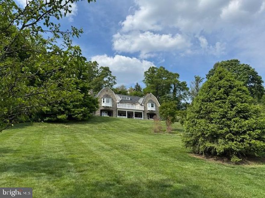 Timeless Elegance Meets Modern Luxury in This One-of-a-Kind Colonial Estate. Perched high above the scenic landscape of Rydal on over 2 acres of beautifully manicured grounds, this fully renovated stone Colonial is the perfect blend of old-world charm and contemporary sophistication. Boasting 5 spacious bedrooms, 3.5 luxurious baths, and over 5,000 square feet of meticulously designed living space, this move-in-ready masterpiece offers unmatched craftsmanship and attention to detail throughout.Step inside through the private drive and into the grand, sunlit foyer where an oversized brick fireplace and a dramatic turned staircase immediately set the tone for what’s to come. The original hardwood floors, solid wood doors, and pocket doors throughout the home echo its rich history, while custom woodwork, oversized doorways, and radiant heated floors provide warmth and elegance. The chef’s dream kitchen is the heart of the home, featuring Thermador appliances, quartz countertops, a marble backsplash, a walk-in pantry, radiant flooring, and an expansive island perfect for entertaining. Adjacent to the kitchen, the light-filled breakfast room and curved study—with a renovated powder room—offer stylish and functional spaces for everyday living. Formal living and dining rooms are equally striking, both showcasing wood-burning fireplaces, custom moldings, and built-ins. Two sets of glass doors in the dining room open to a stunning heated sunroom surrounded by windows, which flows seamlessly to an expansive covered patio with spectacular views—ideal for indoor/outdoor entertaining year-round. Upstairs, the primary suite is a serene retreat complete with his-and-hers built-in closets, crown molding, and a spa-like en suite bathroom featuring an oversized frameless walk-in shower, double quartz vanity, radiant floors, and a dramatic ceiling-mounted waterfall faucet over a soaking tub. Additional bedrooms and renovated full baths line the hallway, and the upper-level laundry room adds convenience. The finished third floor offers versatility as an additional bedroom, home gym, or private office. Outside, a three-car detached garage sits within a charming courtyard, while the new Lennox forced-air heating and cooling system, CertainTeed 50-year roof, security system, and other state-of-the-art mechanical upgrades ensure peace of mind and comfort for years to come. Located just minutes from transportation, shopping, restaurants, top-rated schools, and local parks, this home is a rare find that must be seen to be appreciated. Experience refined living where history meets modern luxury